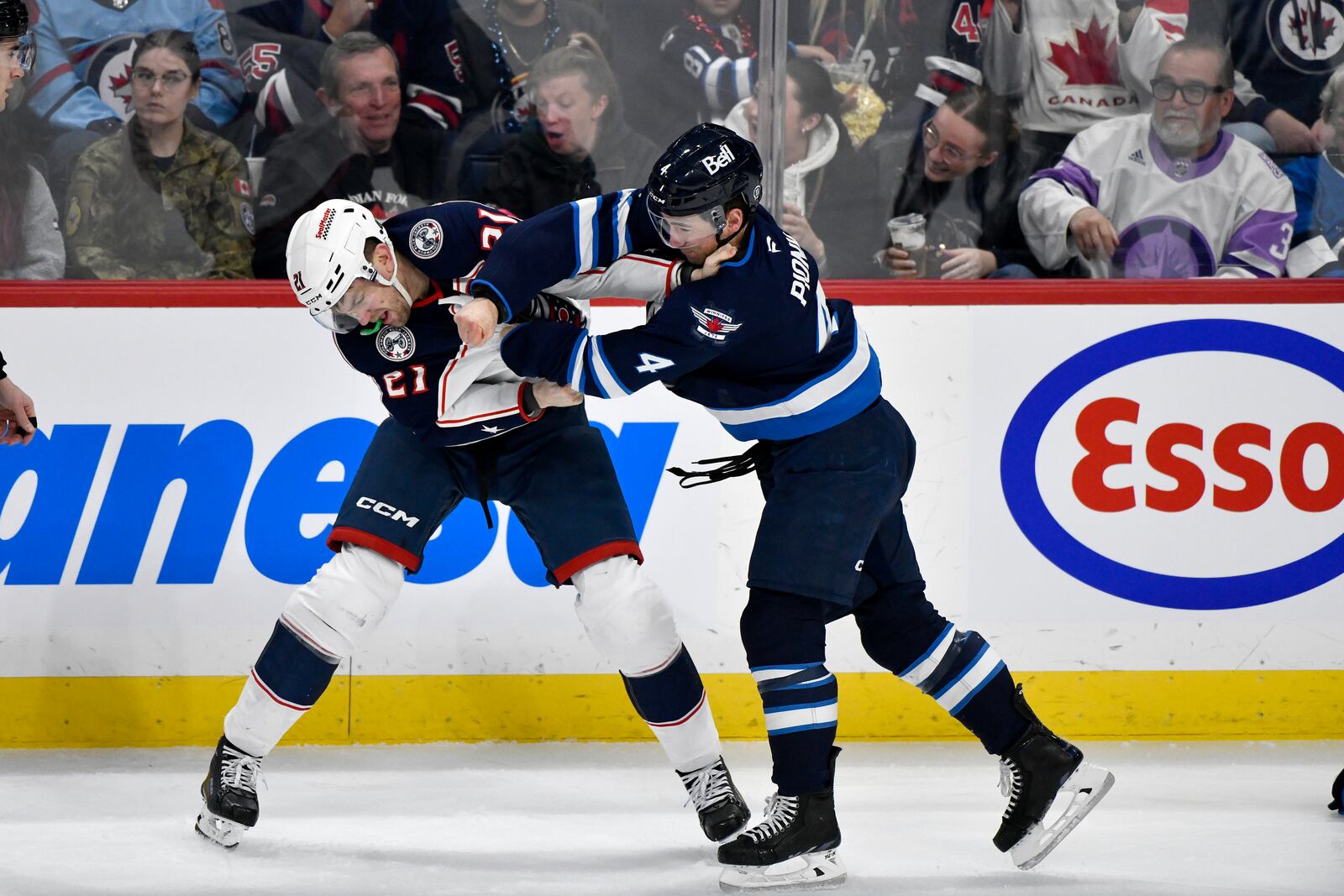 Columbus Blue Jackets' James van Riemsdyk (21) fights Winnipeg Jets' Neal Pionk (4) during first-period NHL hockey game action in Winnipeg, Manitoba, Sunday Dec. 8, 2024. (Fred Greenslade/The Canadian Press via AP)