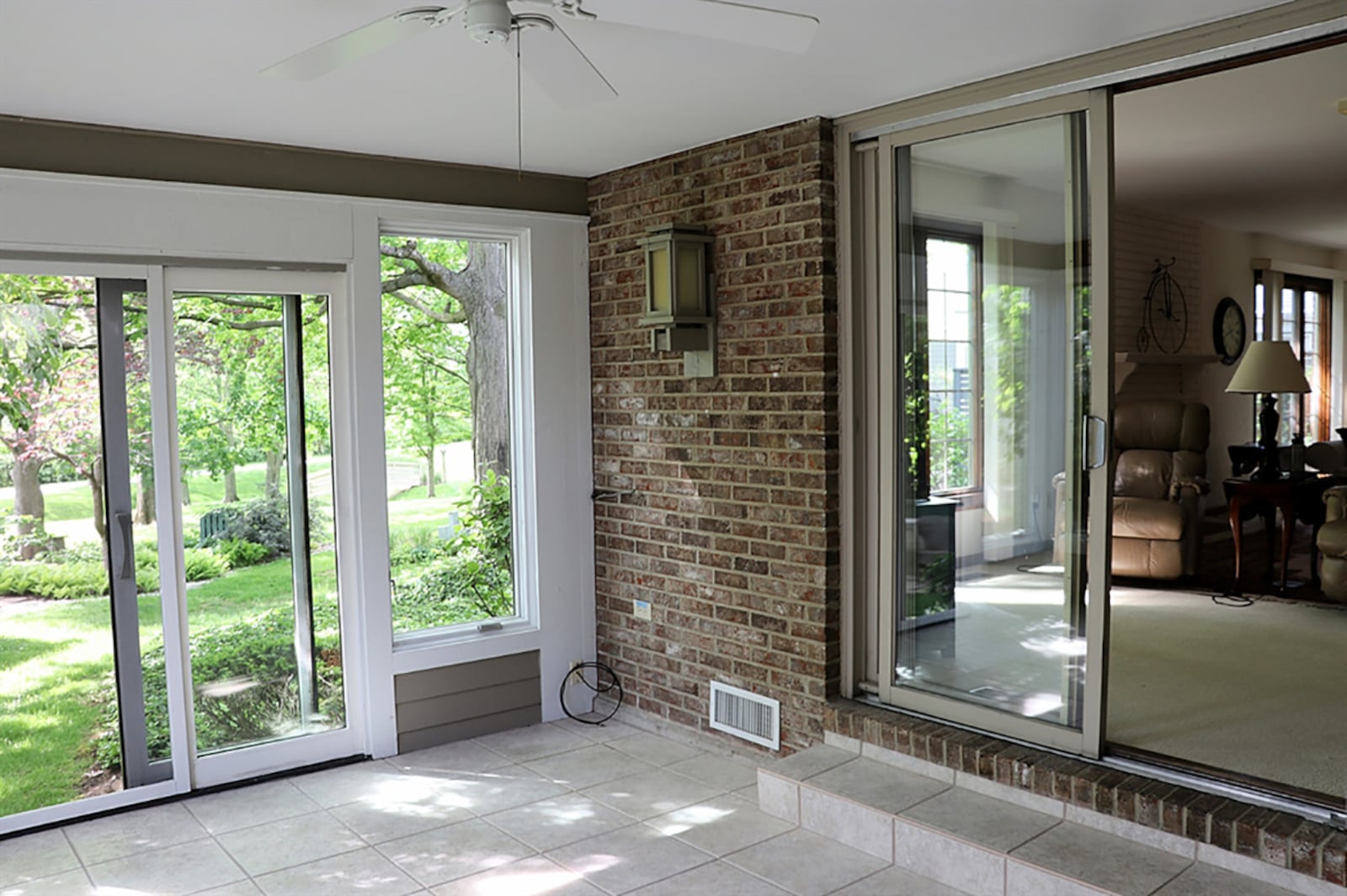 Sliding patio doors open off the living room into a sun room with ceramic-tile flooring, ceiling paddle fans and panoramic views of the common area and gardens. CONTRIBUTED PHOTO BY KATHY TYLER