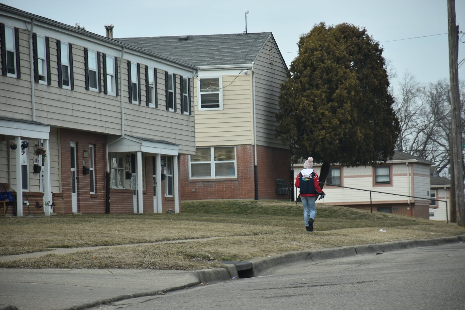 A woman walks along Ingram Street in West Dayton, which  officials say is the last place Jack Flohre was seen before he went missing in January 2023. CORNELIUS FROLIK / STAFF