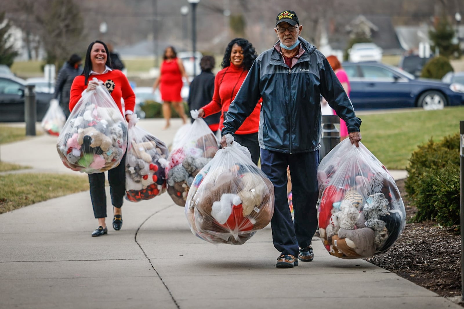 From left, Dea Anna Buell, Leo Gilyot and Asenah Taylor carry hundreds of teddy bears into Montgomery County Children Services on Tuesday, Feb. 14, 2023. The Dayton Section of the National Council of Negro Women has donated bears for Dayton area children on Valentine's Day for more than 20 years at various organizations in the community. JIM NOELKER/STAFF