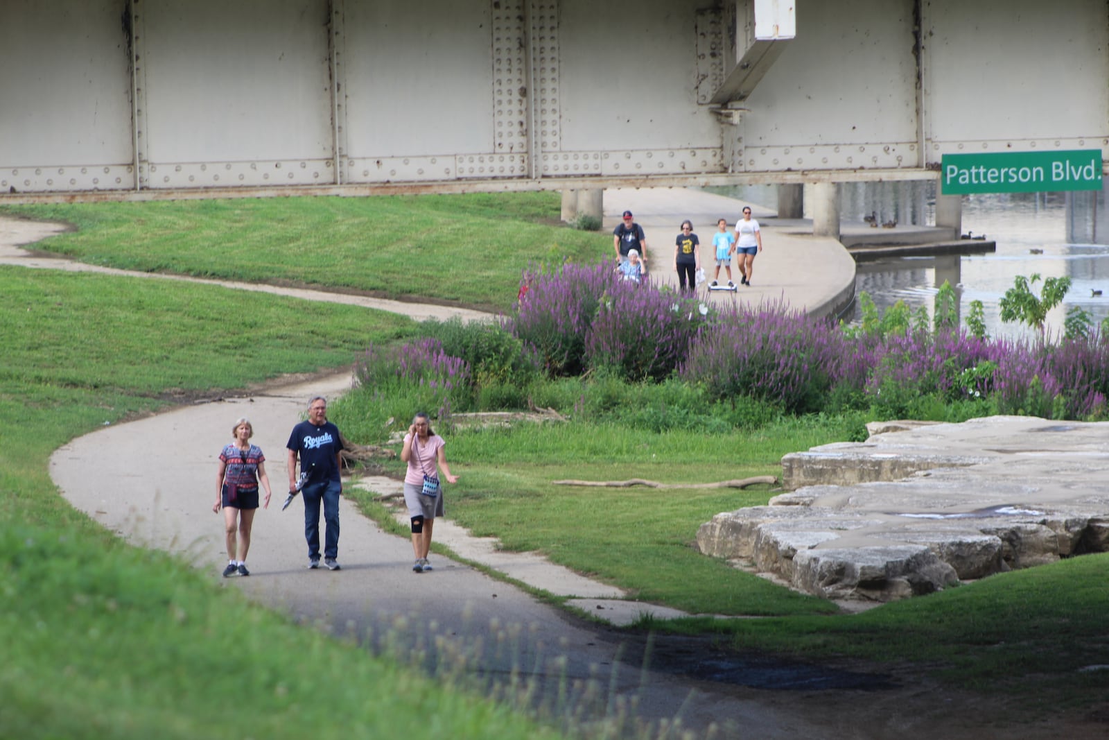 People walk along the river at RiverScape MetroPark in downtown Dayton. CORNELIUS FROLIK / STAFF