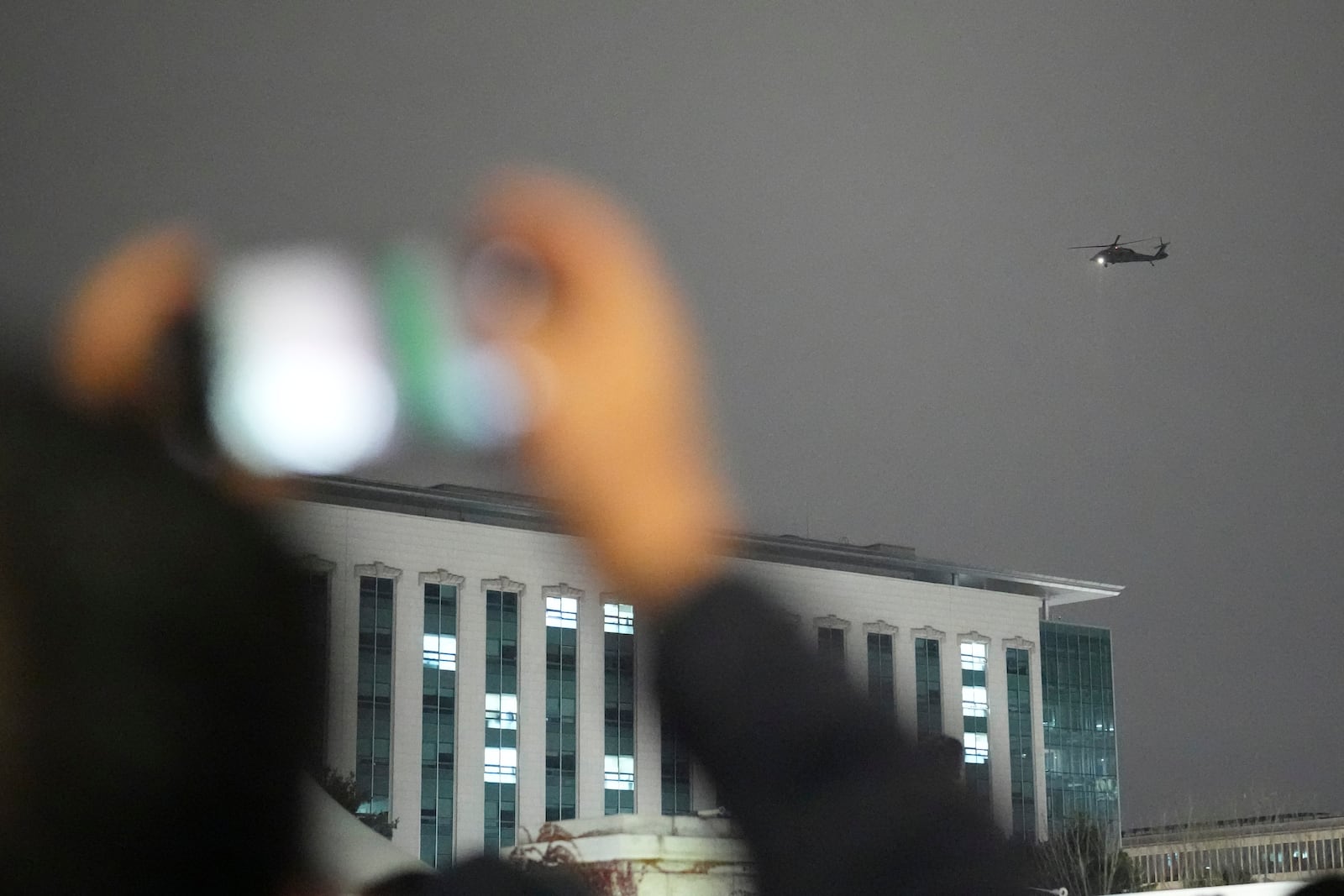 A helicopter flies over the National Assembly in Seoul, South Korea, Wednesday, Dec. 4, 2024. (AP Photo/Lee Jin-man)