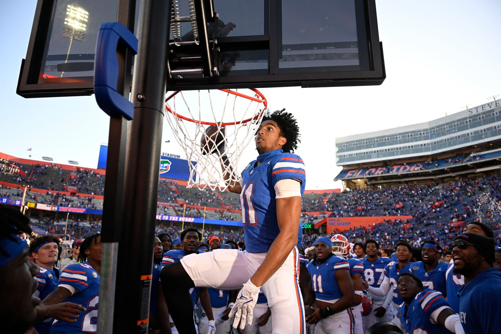 Florida wide receiver Aidan Mizell (11) performs a celebratory dunk using a basketball backboard placed on the Mississippi sideline after their 24-17 win in an NCAA college football game, Saturday, Nov. 23, 2024, in Gainesville, Fla. (AP Photo/Phelan M. Ebenhack)