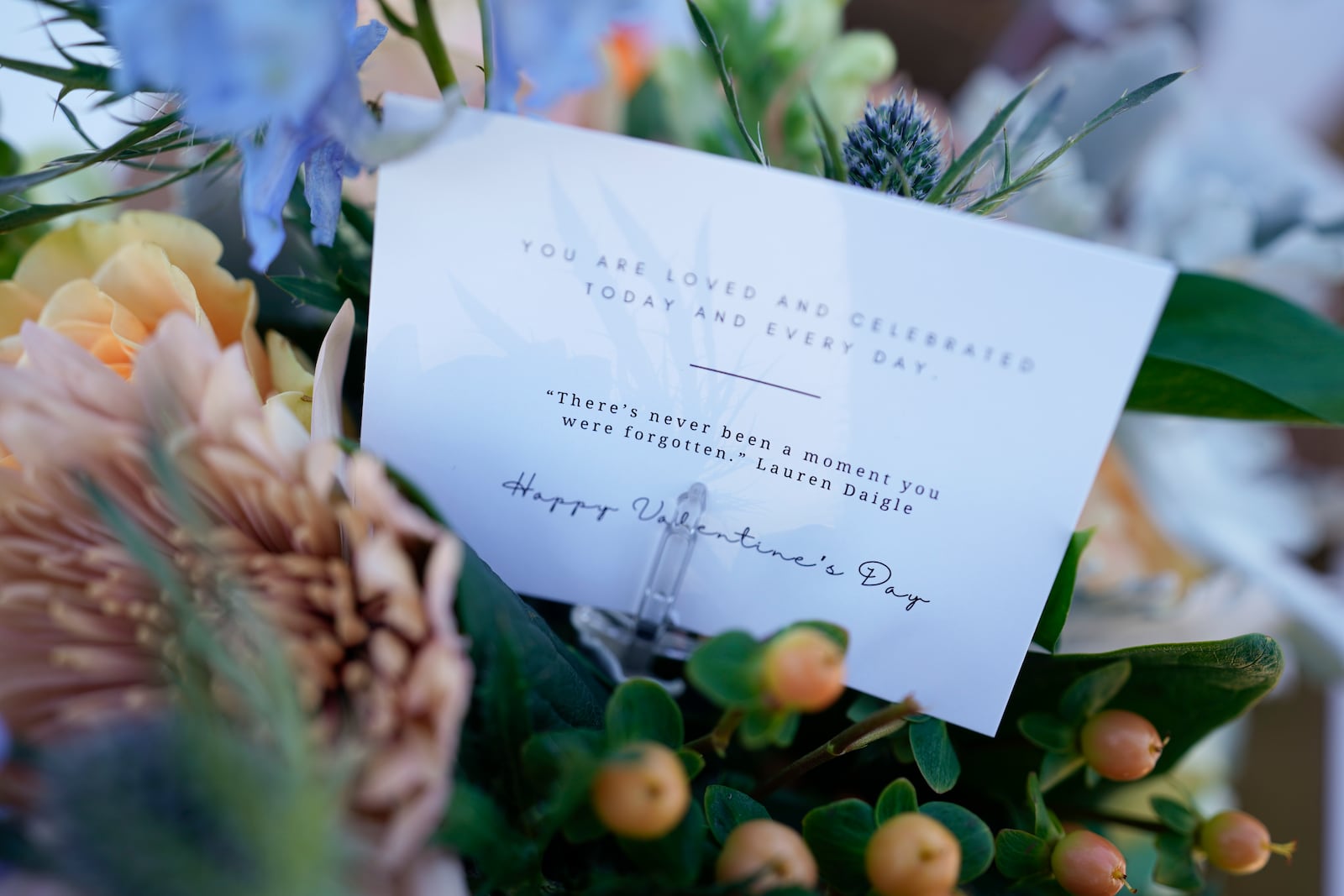 A note inside a flower arrangement is seen during a Valentine's Day Widow Outreach Project event, Friday, Feb. 14, 2025, in Charlotte, N.C. (AP Photo/Erik Verduzco)