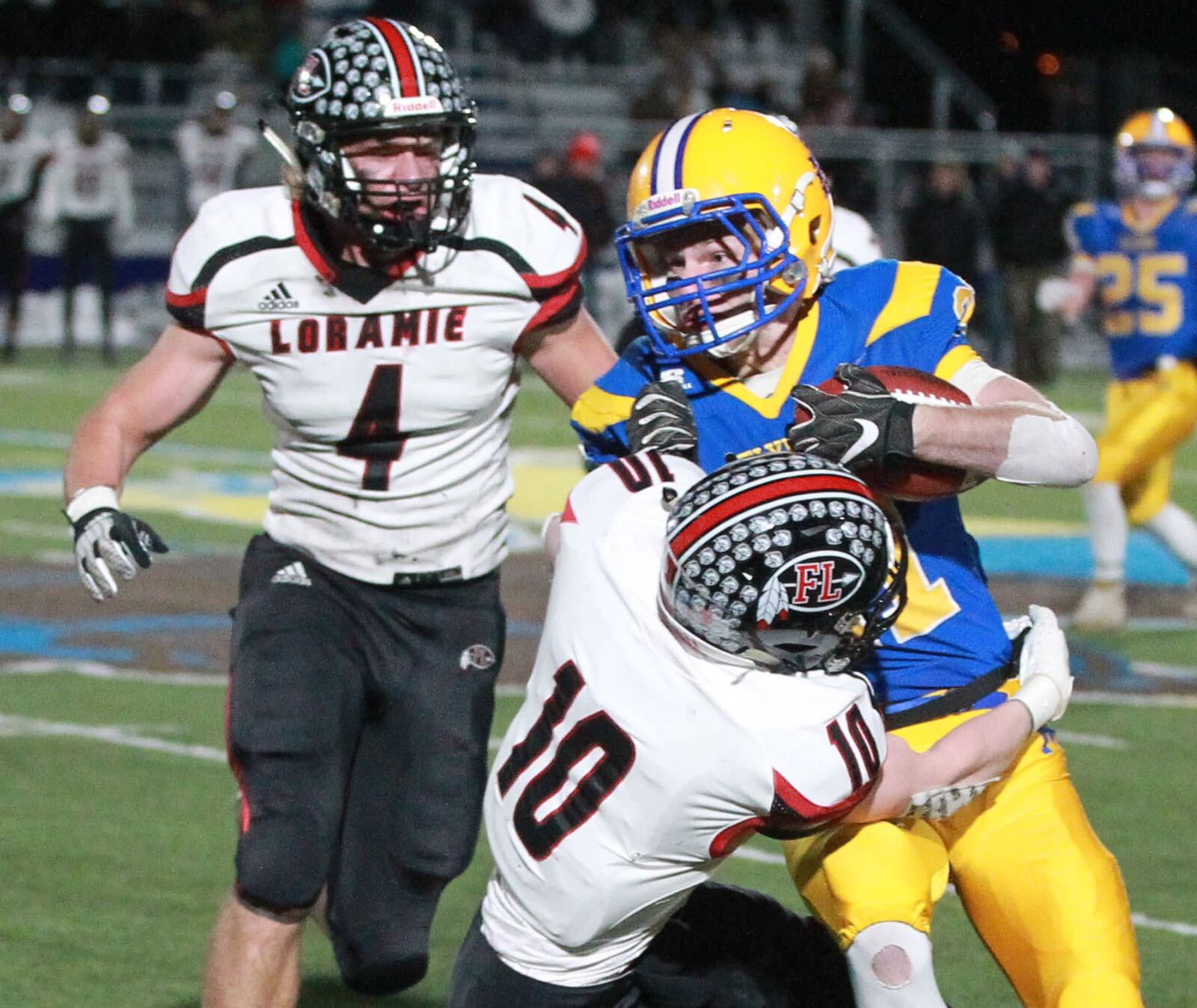 Dylan Heitkamp of Marion Local (with ball) is met by Nick Brandewie (4) and Sam Barhorst of Fort Loramie. Marion Local defeated Fort Loramie 24-21 in OT in a Division VII, Region 28 high school football regional semifinal at St. Marys Memorial on Saturday, Nov. 16, 2019. MARC PENDLETON / STAFF