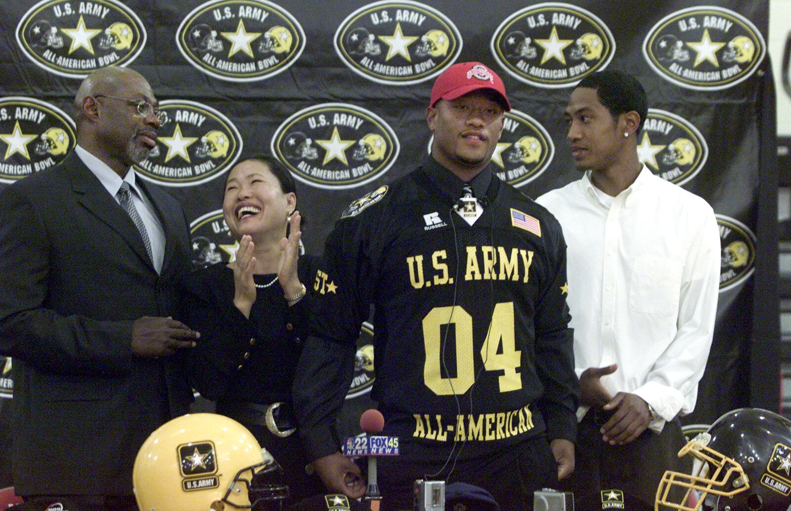 Surrounded by his family on Sept. 24, 2003, Wayne High School linebacker Marcus Freeman, second from right, announces his decision to play football for the Ohio State University at the end of a school assembly honoring his selection for the U.S. Army All-American team.  Freeman was highly sought after by  virtually all of the big football colleges. His father Michael Freeman, mother Chong, and brother Michael Jr. stood by him for the announcement. Jan Underwood/Staff