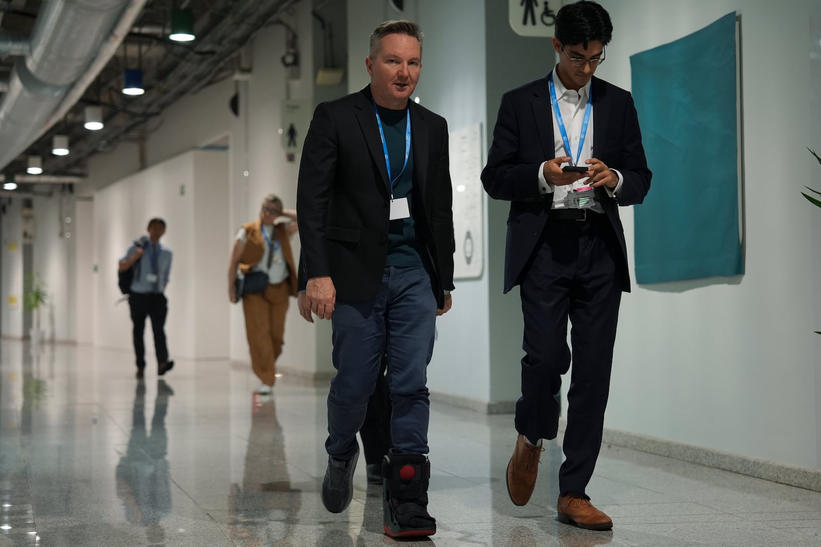 Australia Climate Minister Chris Bowen, center, walks through a hallway at the COP29 U.N. Climate Summit in the early hours of Saturday, Nov. 23, 2024, in Baku, Azerbaijan. (AP Photo/Joshua A. Bickel)