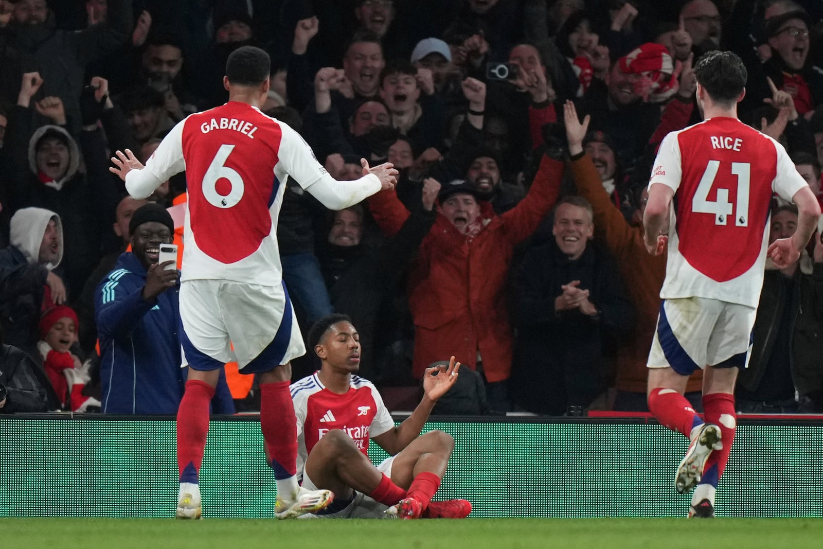 Arsenal's Myles Lewis-Skelly, bottom, celebrates scoring his side's 3rd goal during the English Premier League soccer match between Arsenal and Manchester City at the Emirates stadium in London, Sunday, Feb. 2, 2025. (AP Photo/Alastair Grant)