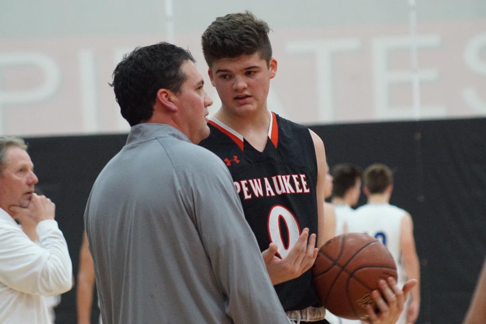 Grant Basile gets instruction during a Pewaukee High School game from his dad Michael, who was the Pirates head coach. CONTRIBUTED