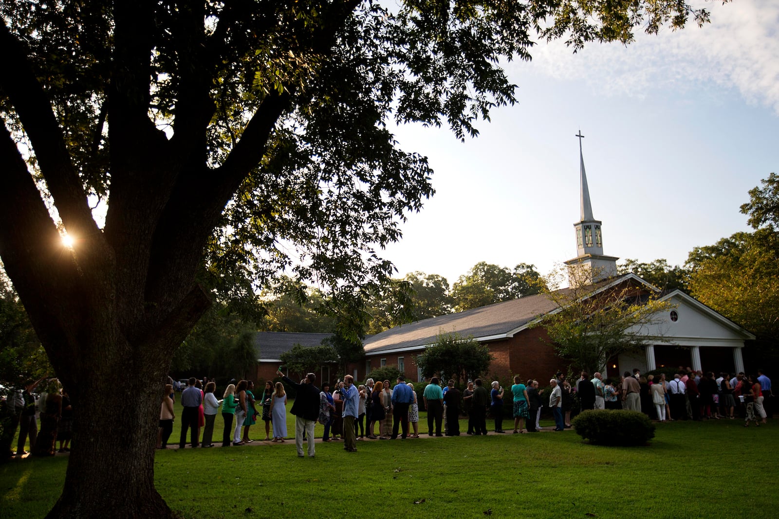 FILE - People wait in line outside Maranatha Baptist Church in Plains, Ga., to get into a Sunday school class taught by former U.S. President Jimmy Carter on Aug. 23, 2015. It was Carter's first lesson since announcing plans for intravenous drug doses and radiation to treat melanoma found in his brain after surgery to remove a tumor from his liver. (AP Photo/David Goldman, File)