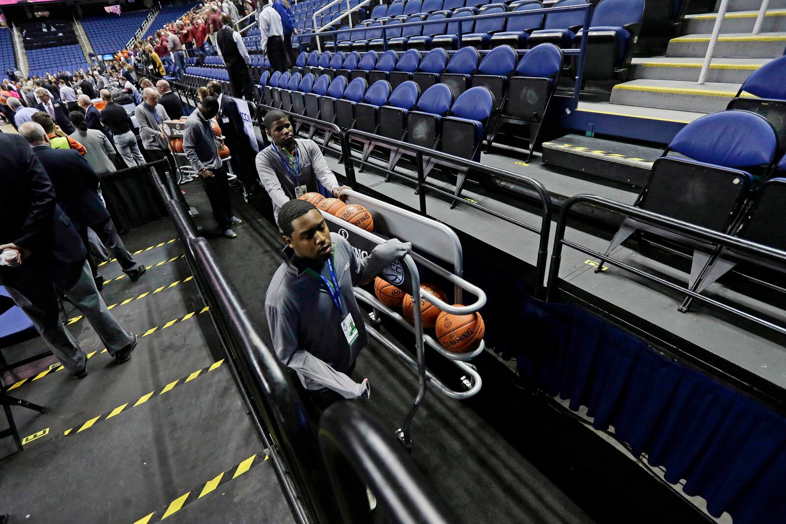 FILE - Personnel remove the balls from the playing court after the NCAA college basketball games at the Atlantic Coast Conference tournament were canceled due to coronavirus concerns, Thursday, March 12, 2020, in Greensboro, N.C. (AP Photo/Gerry Broome, File)