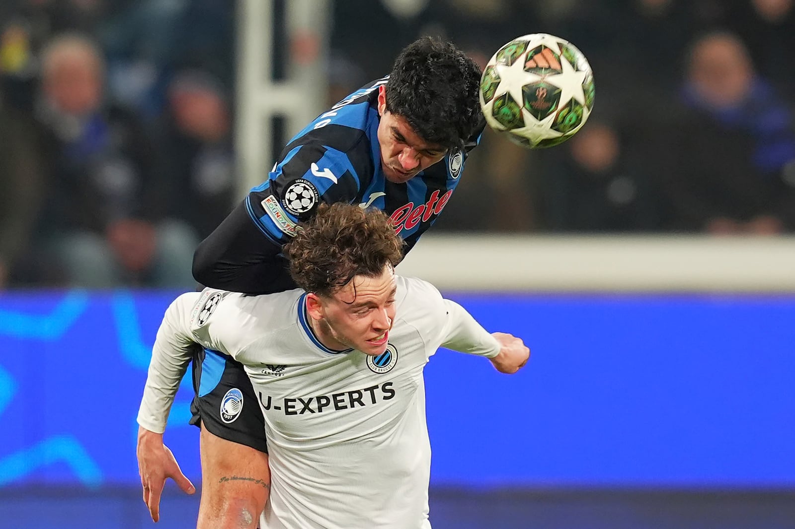 Atalanta's Raoul Bellanova, top, heads the ball over Brugge's Maxim De Cuyper during a Champions League, playoff second leg, soccer match between Atalanta and Club Brugge in Bergamo, Italy, Tuesday, Feb.18, 2025. (Spada/LaPresse via AP)