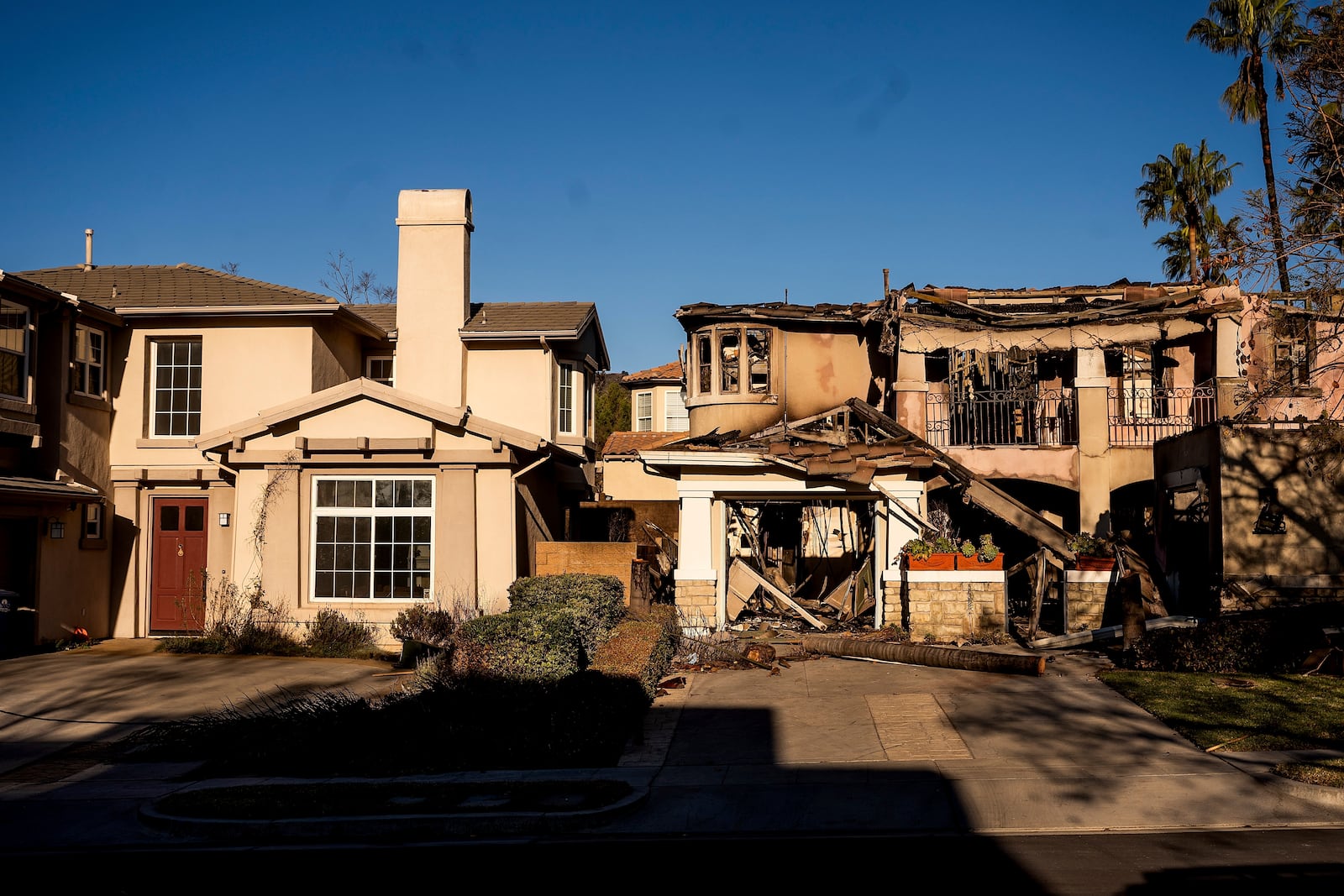 FILE - A home destroyed by the Eaton Fire, right, stands next a home that survived in Altadena. Calif., on Monday, Jan. 13, 2025. (AP Photo/Noah Berger, File)