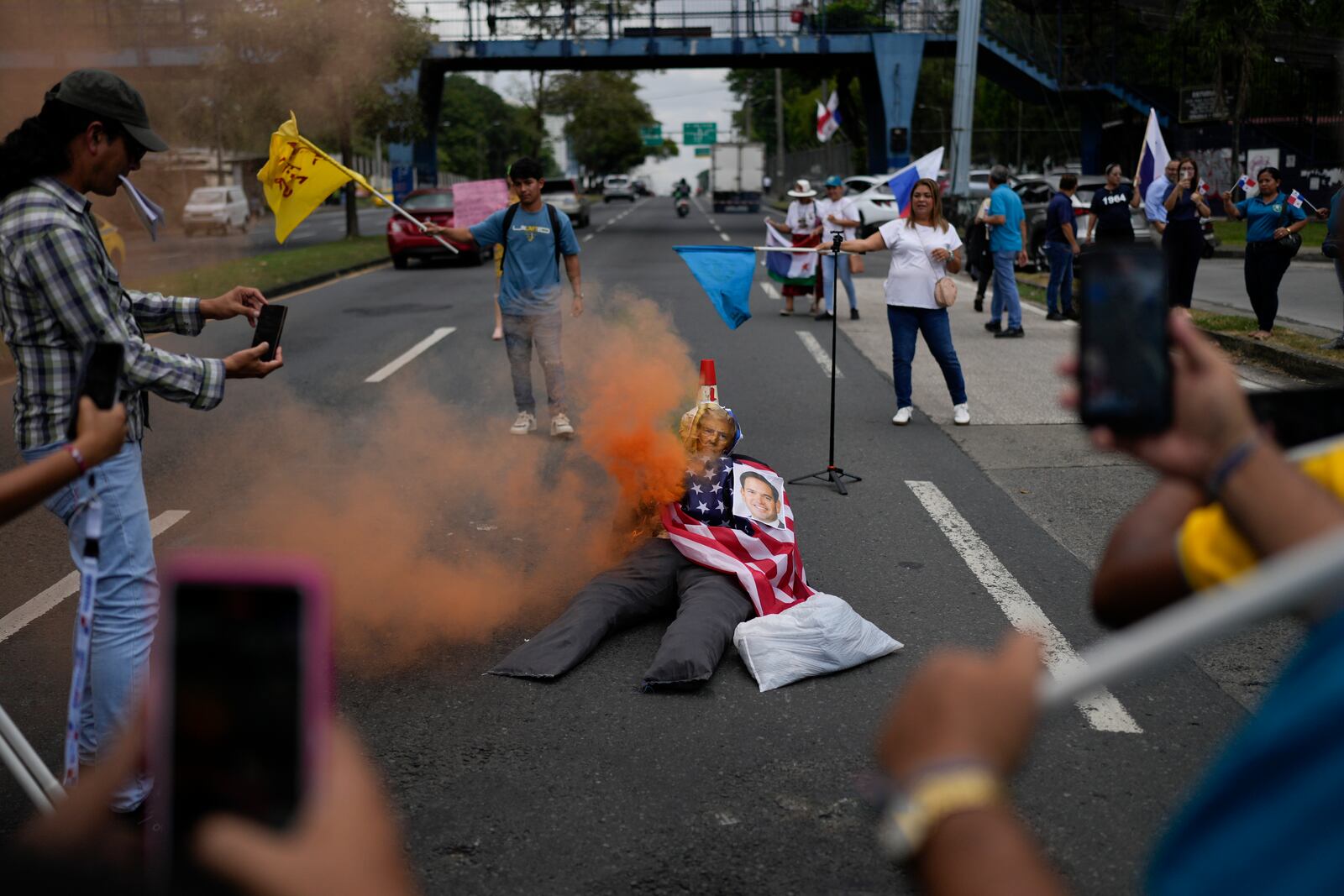 Demonstrators watch their effigy of U.S. President Donald Trump, also featuring a photo of Secretary of State Marco Rubio, start to burn as they protest Rubio's upcoming visit to Panama City, Friday, Jan. 31, 2025. (AP Photo/Matias Delacroix)