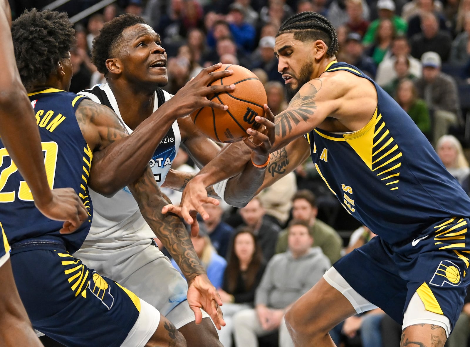 Minnesota Timberwolves guard Anthony Edwards, second from right, is fouled by Indiana Pacers guard Quenton Jackson, left, as he drives to the basket past forward Obi Toppin, right, during overtime of an NBA basketball game Monday, March 17, 2025, in Minneapolis. (AP Photo/Craig Lassig)