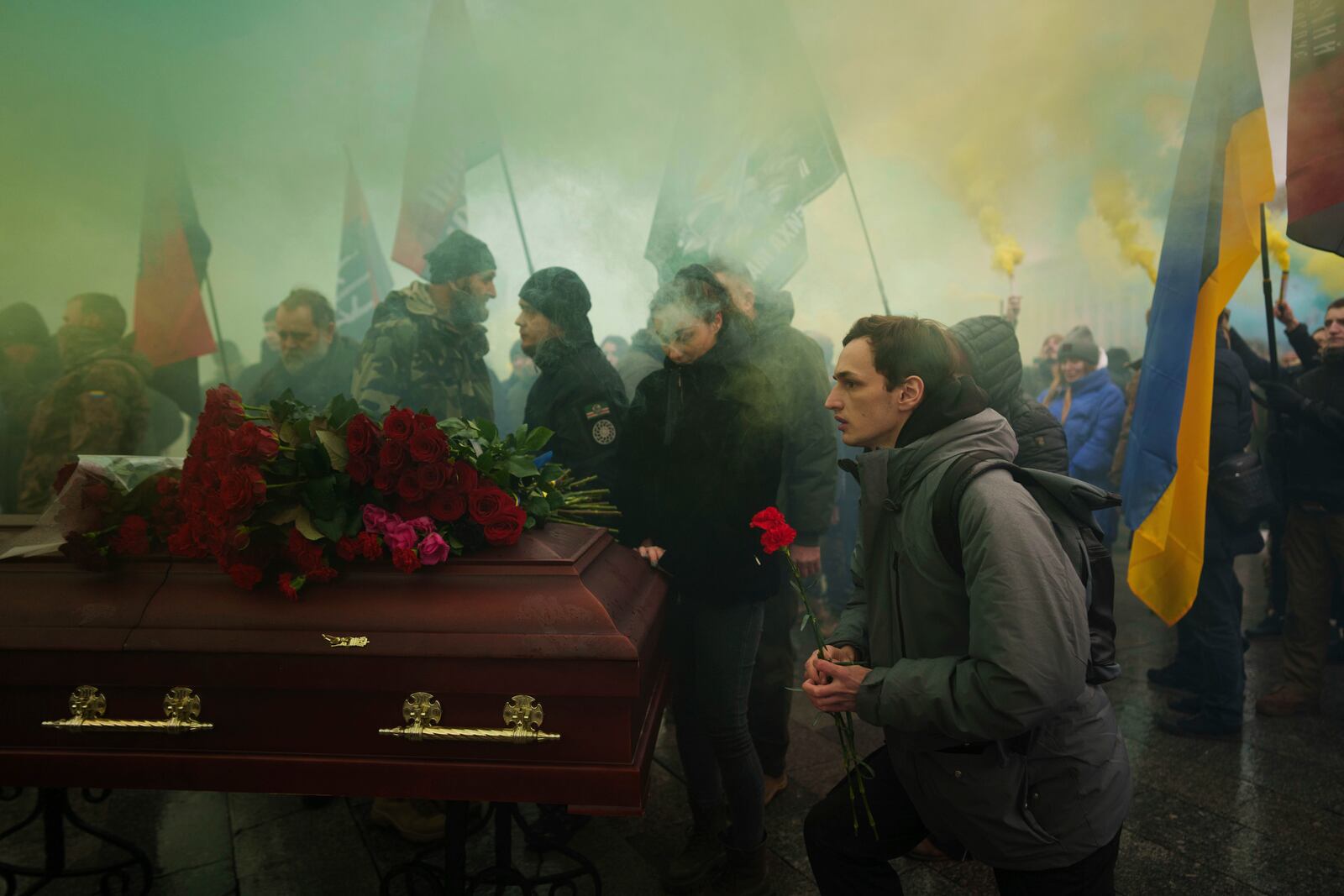 A man gives his last salute to a Ukrainian officer Pavlo Vedybida aka "Obolonchik" during funeral ceremony on Independence square in Kyiv, Ukraine, Saturday, Nov. 30, 2024. (AP Photo/Evgeniy Maloletka)