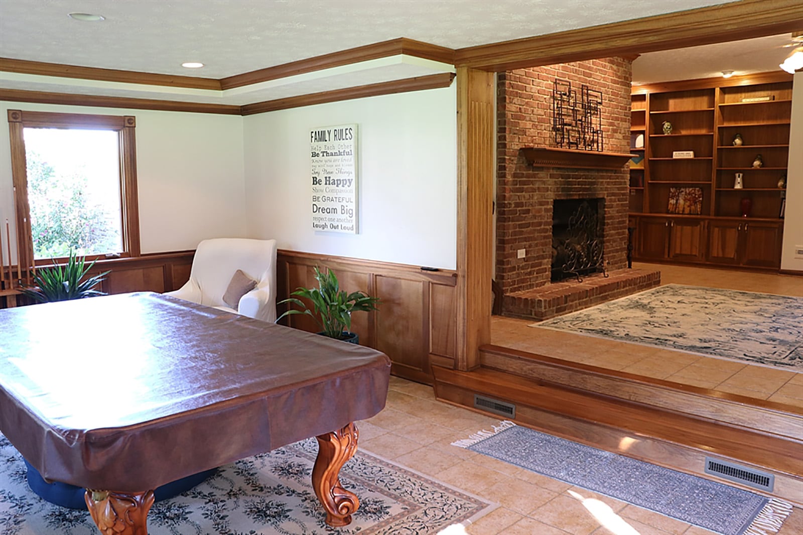 A brick, gas fireplace is the centerpiece to the centrally located family room. The fireplace has a brick hearth and dentil wood mantel that matches the crown molding. Ceramic-tile flooring fills the family room and continues two-steps down into the 4-season. CONTRIBUTED PHOTO BY KATHY TYLER