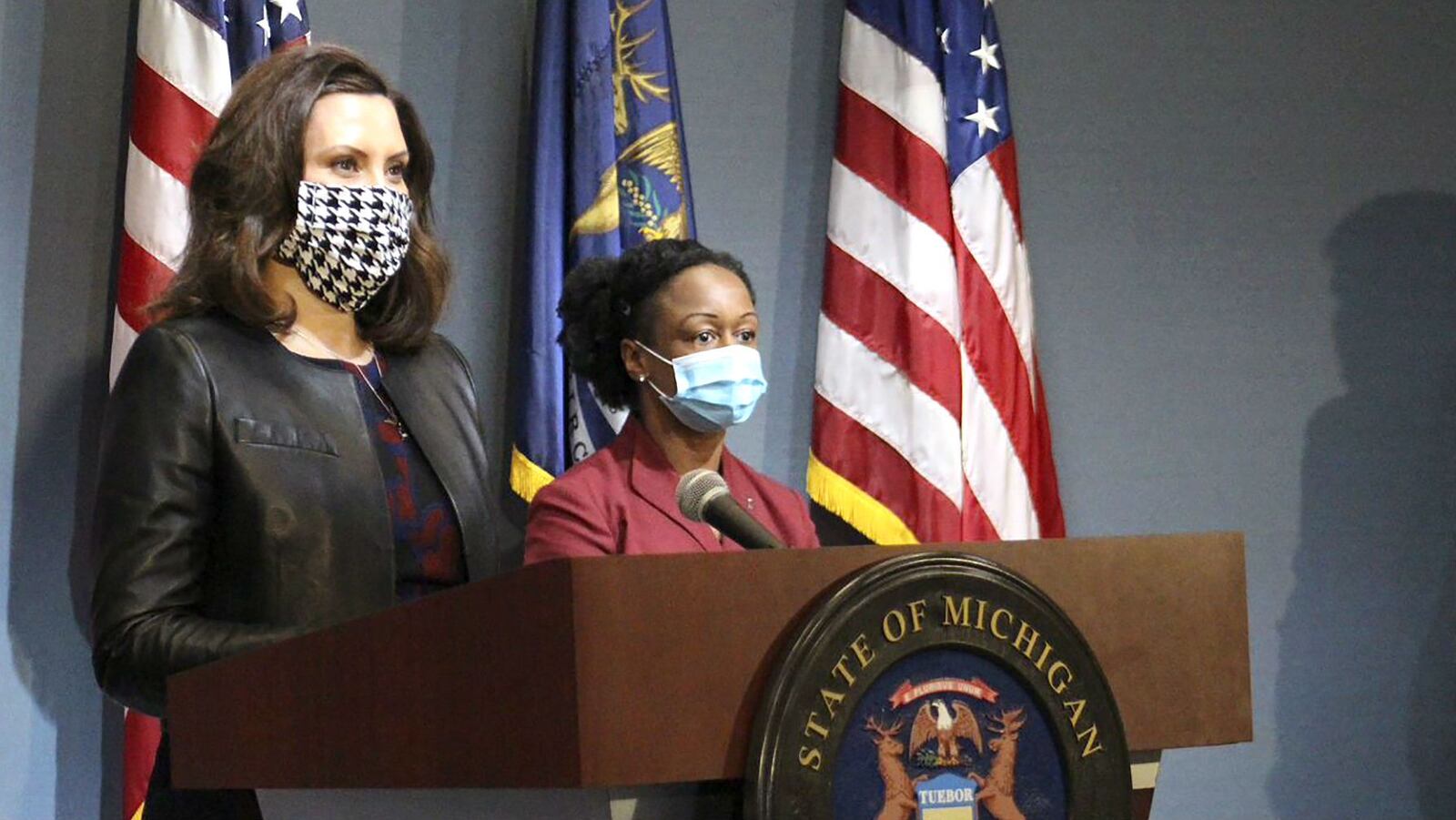 Michigan Gov. Gretchen Whitmer, left, wearing a mask, addresses the state during a speech in Lansing, Mich., Friday, May 1, 2020.