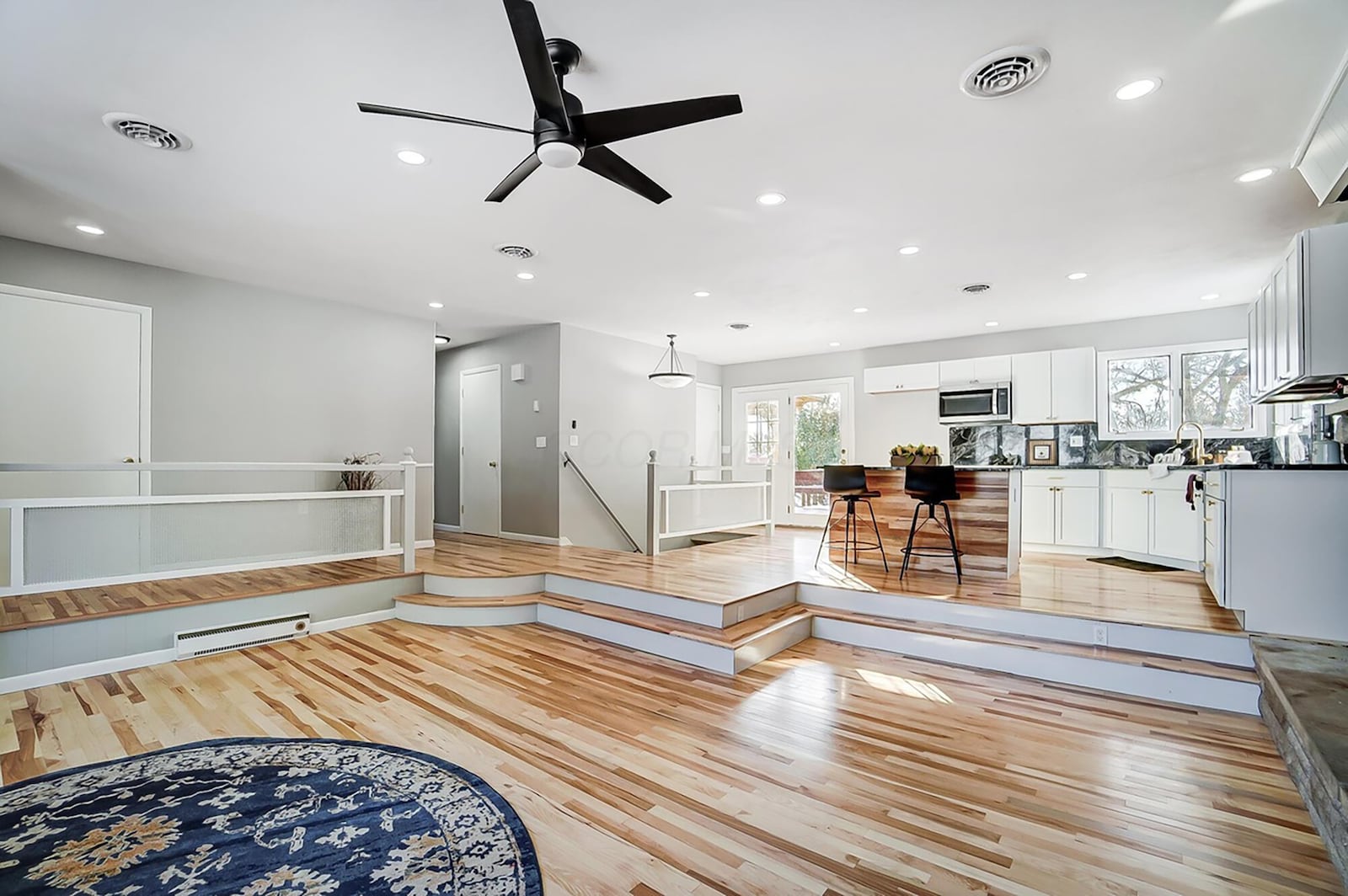 The open concept living room and kitchen has hardwood flooring throughout. The living room has a wood burning fireplace with stove insert