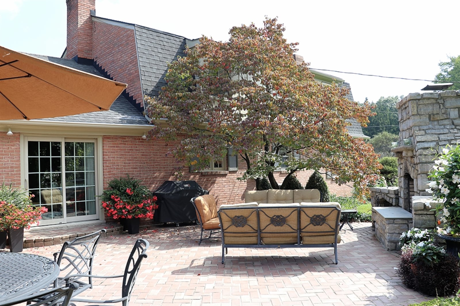 The outdoor entertainment area is surrounded by mature evergreens and landscaping for added privacy.