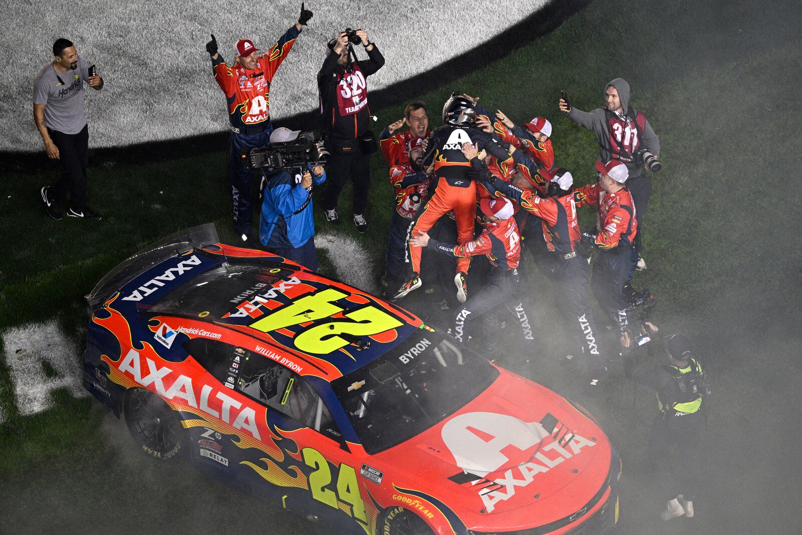 William Byron leaps from the top of his car into the arms of crew members after winning the NASCAR Daytona 500 auto race at Daytona International Speedway, Sunday, Feb. 16, 2025, in Daytona Beach, Fla. (AP Photo/Phelan M. Ebenhack)