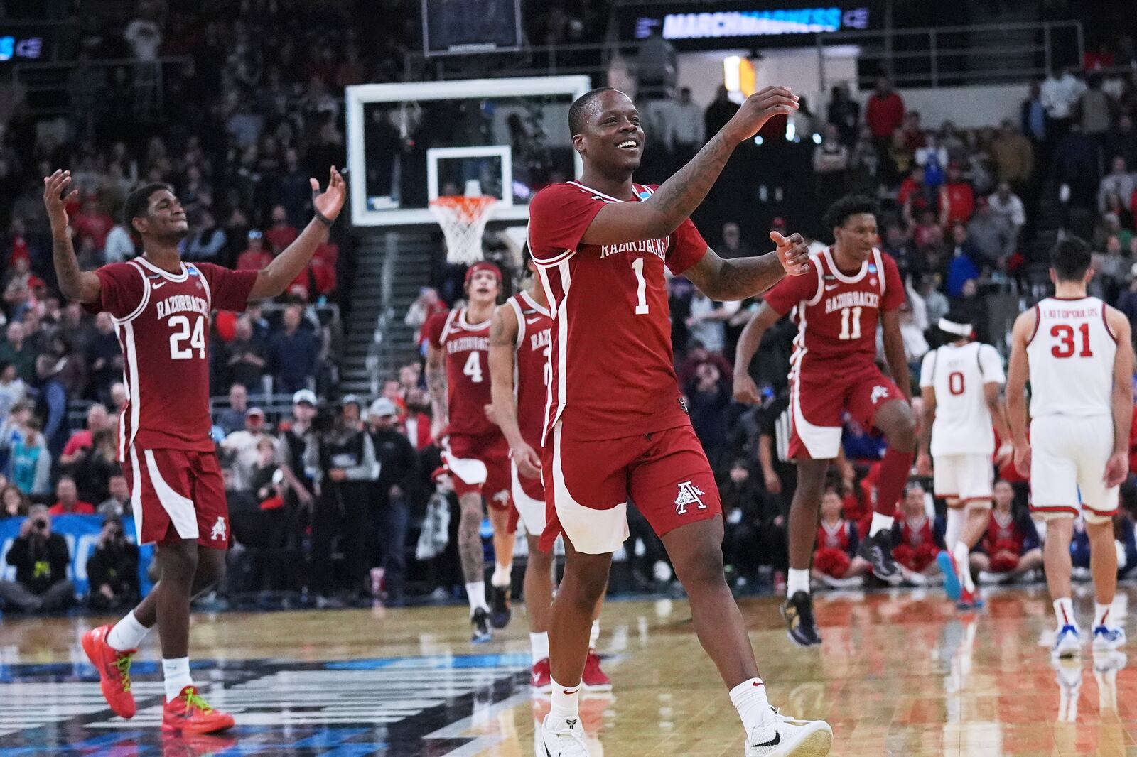 Arkansas guard Johnell Davis (1) celebrates with his teammates after defeating St. John's in the second round of the NCAA college basketball tournament, Saturday, March 22, 2025, in Providence, R.I. (AP Photo/Charles Krupa)