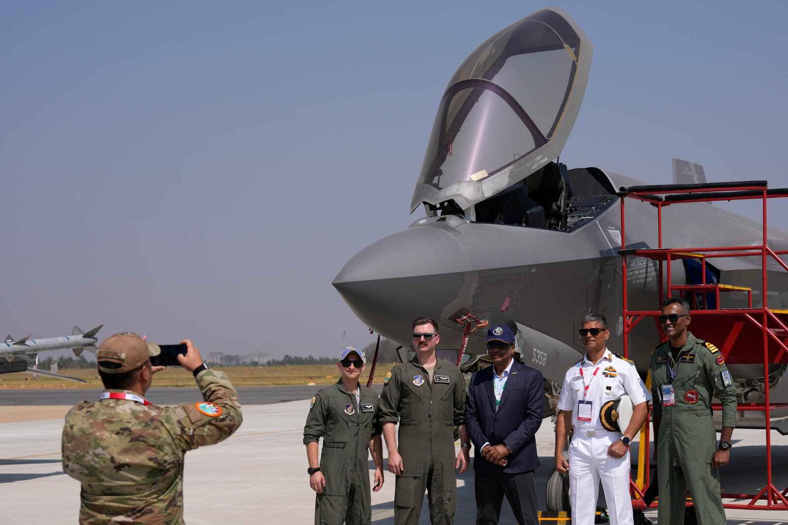 Indian naval officers, right, pose with the U.S. Air Force officers in front of the F-35 fighter aircraft at the static display area on the last day of the Aero India 2025, a biennial event, at Yelahanka air base in Bengaluru, India, Friday, Feb. 14, 2025. (AP Photo/Aijaz Rahi)