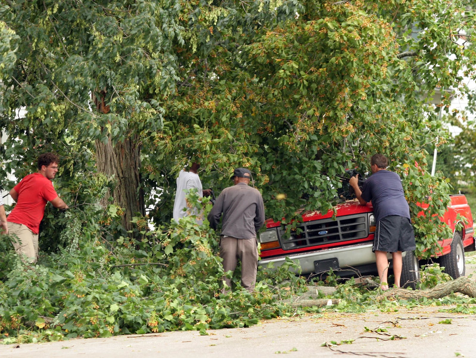 Tree branches are removed from atop a pick-up truck along Short St. in Troy Sunday afternoon. Severe winds from Hurricane Ike caused heavy damage across the entire Miami Valley. Staff photo by Jim Witmer