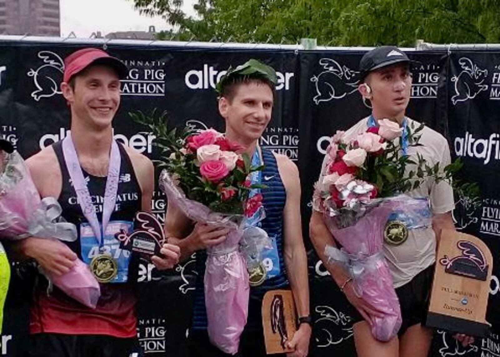 Jason Salyer, center, poses for a photo after winning the Flying Pig Marathon on Sunday, May 7, 2023, in Cincinnati. Photo by Jim Salyer