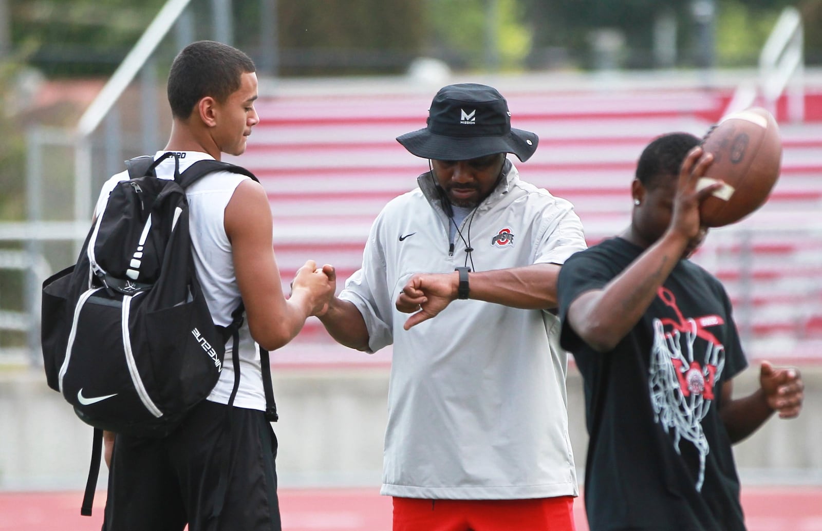 New Wayne High School head football coach Roosevelt Mukes (center) huddles with junior starting QB Cam Fancher. The Warriors held their first preseason football practice on Thursday, Aug. 1, 2019. MARC PENDLETON / STAFF