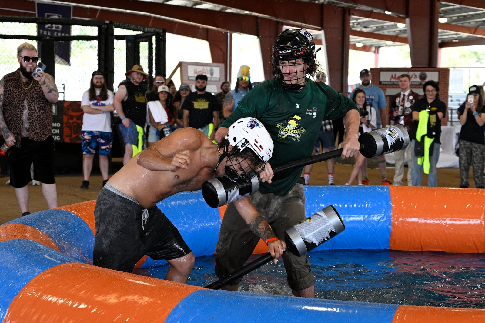 Jonathan Ramirez, left, of Orlando, Fla., and Liam Jones, of St. Augustine, Fla., compete in the Weaponized Pool Noodle Mud Wrestling event during the Florida Man Games, Saturday, March 1, 2025, in Elkton, Fla. (AP Photo/Phelan M. Ebenhack)