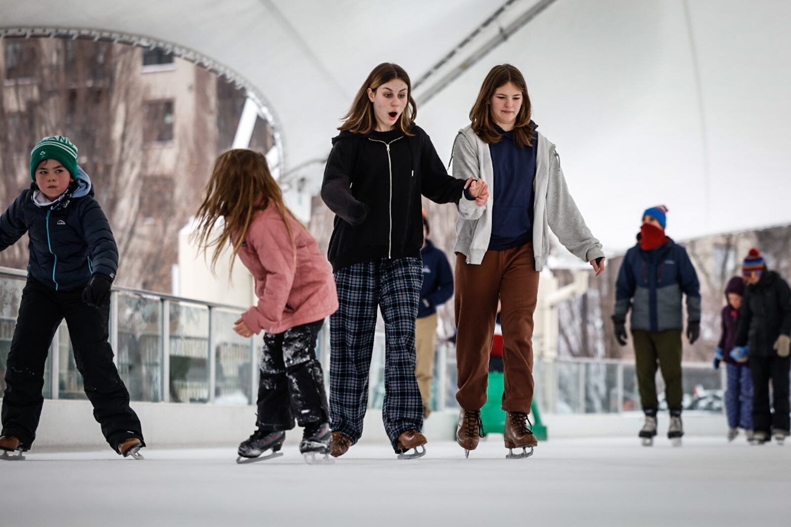 Annie Mlazovsky, left center and Brynn Good enjoy the MetroPark ice Rink at RIverscape on East Monument Ave. Tuesday December 27, 2022. Both girls are from Dayton. JIM NOELKER/STAFF