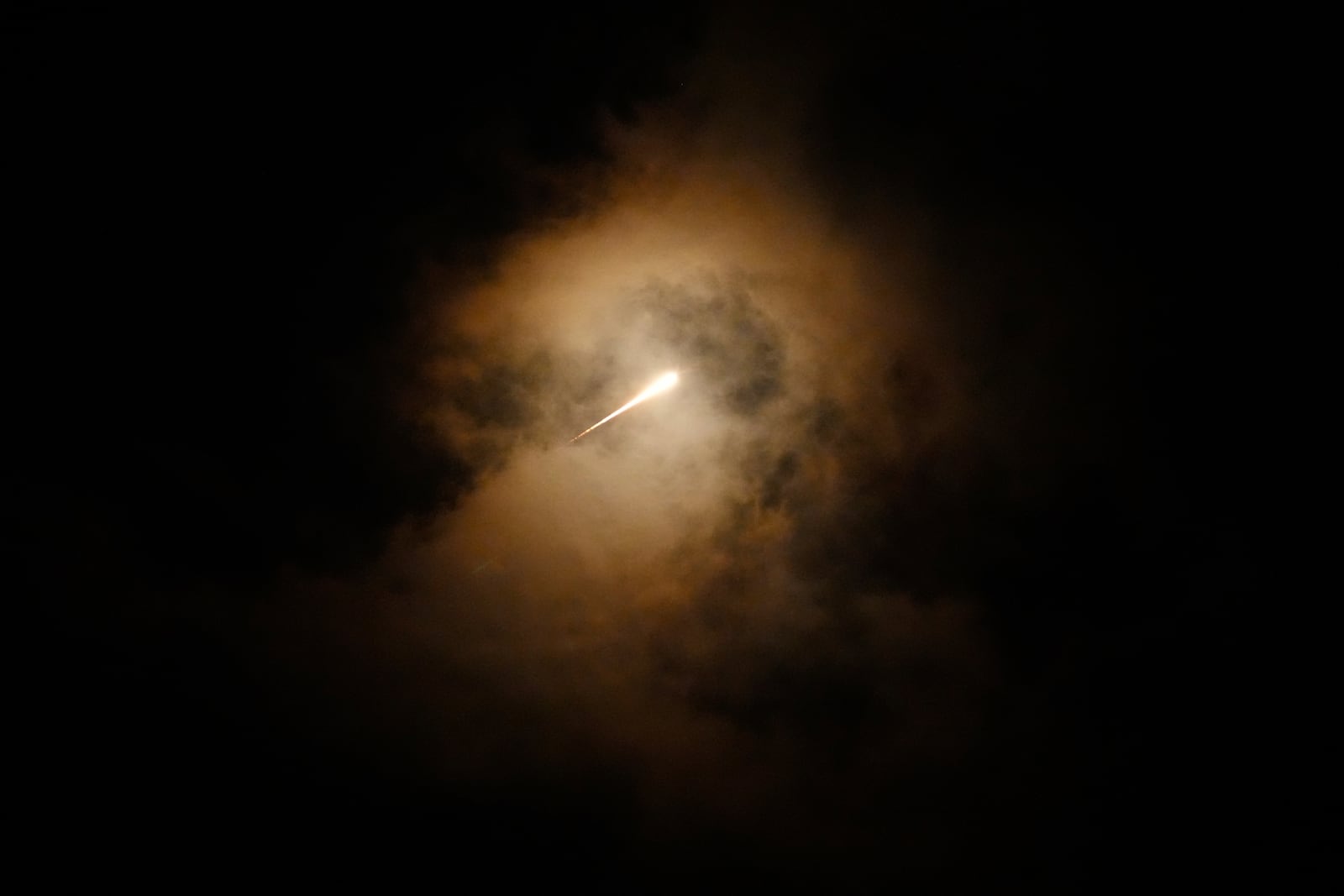 FILE - Projectiles fly through the sky in central Israel as a siren sounds a warning of incoming missiles fired from Iran towards Israel, Oct. 1, 2024. (AP Photo/Ohad Zwigenberg, File)