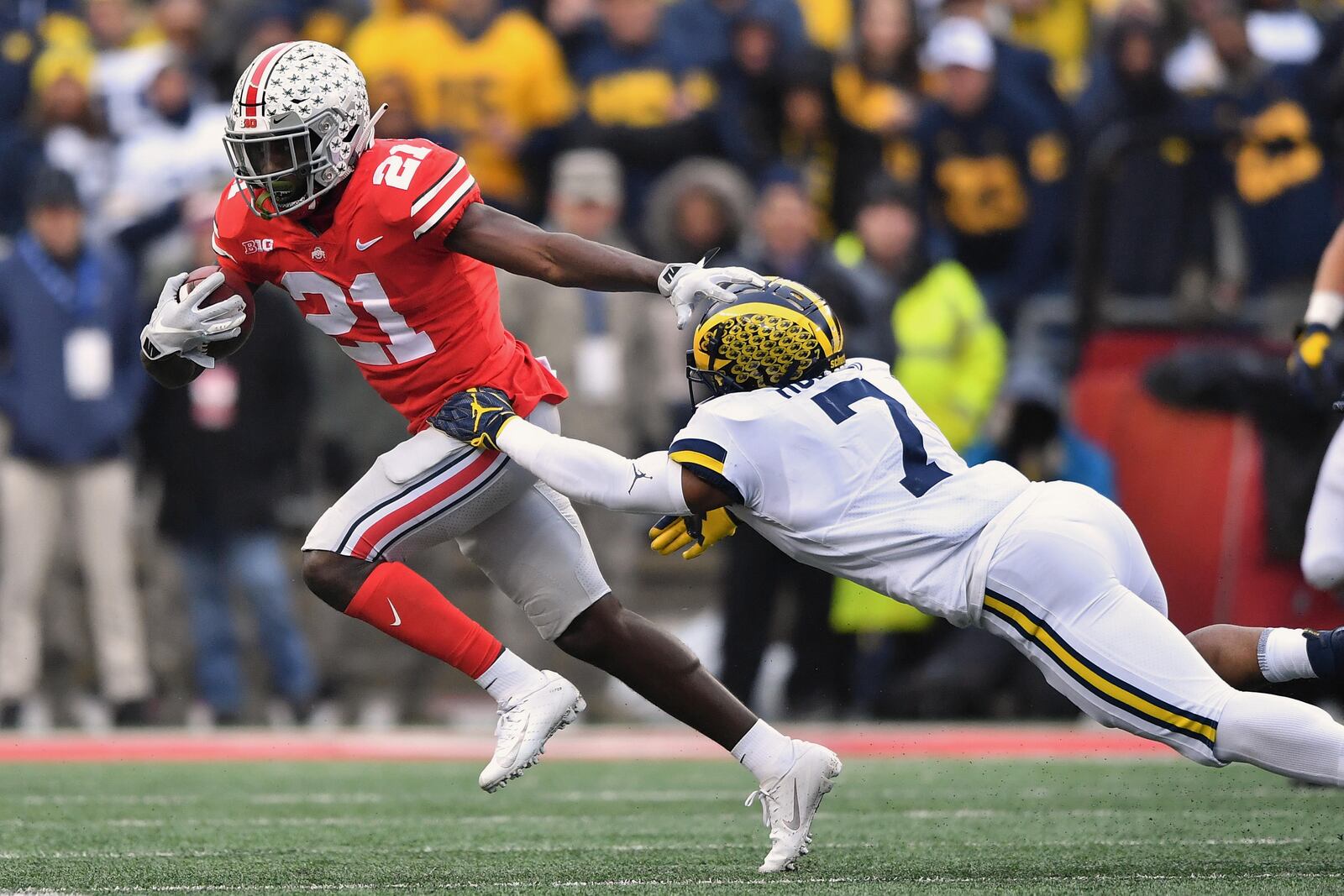 COLUMBUS, OH - NOVEMBER 24:  Parris Campbell #21 of the Ohio State Buckeyes outruns the tackle attempt from Khaleke Hudson #7 of the Michigan Wolverines in the second quarter at Ohio Stadium on November 24, 2018 in Columbus, Ohio. Ohio State defeated Michigan 62-39.  (Photo by Jamie Sabau/Getty Images)