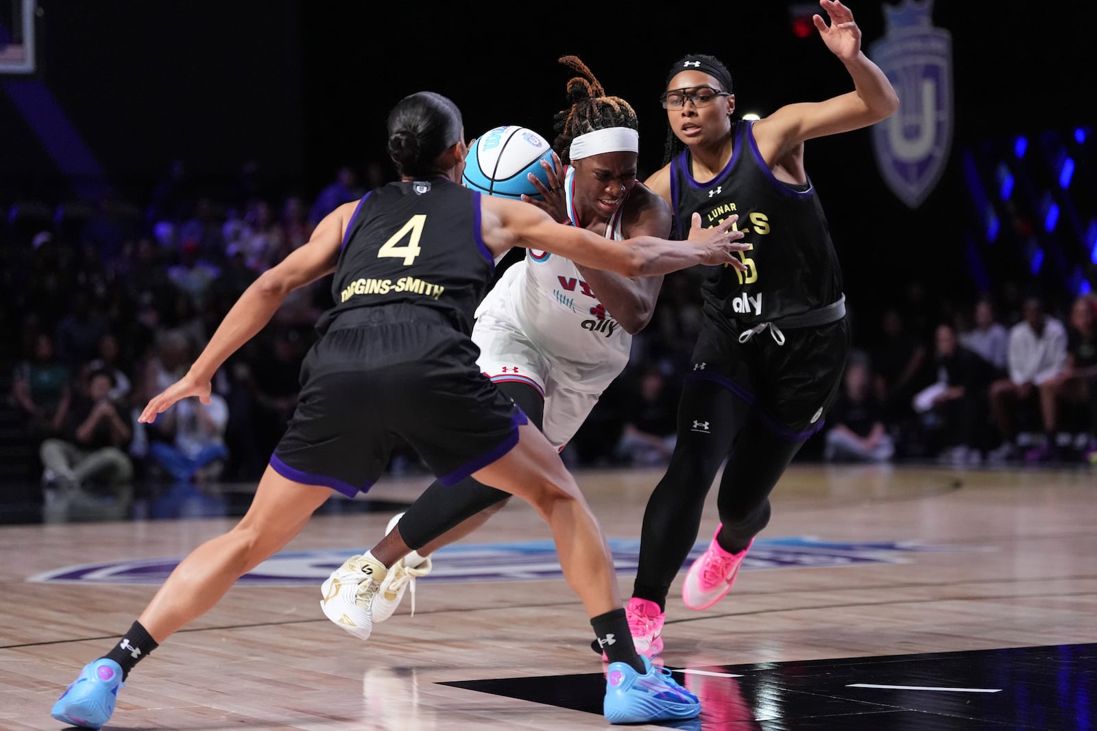 Vinyl wing Rhyne Howard, center, powers forward under pressure from Lunar Owls wing Allisha Gray, right, and guard Skylar Diggins-Smith (4) in their Unrivaled 3-on-3 basketball semifinal, Sunday, March 16, 2025, in Medley, Fla. (AP Photo/Rebecca Blackwell)