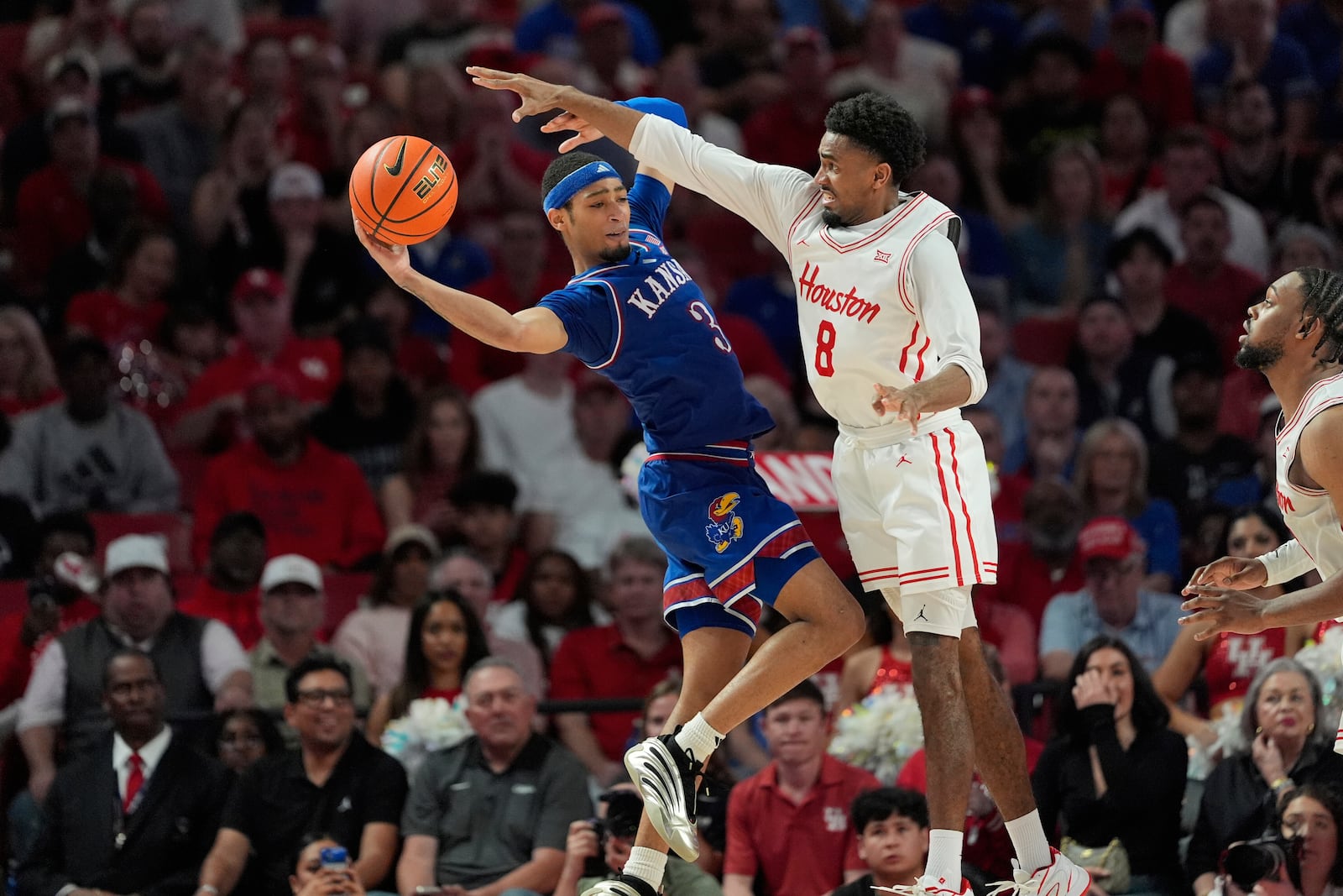 Houston's Mylik Wilson (8) defends against Kansas' Dajuan Harris Jr. (3) during the second half of an NCAA college basketball game Monday, March 3, 2025, in Houston. (AP Photo/David J. Phillip)