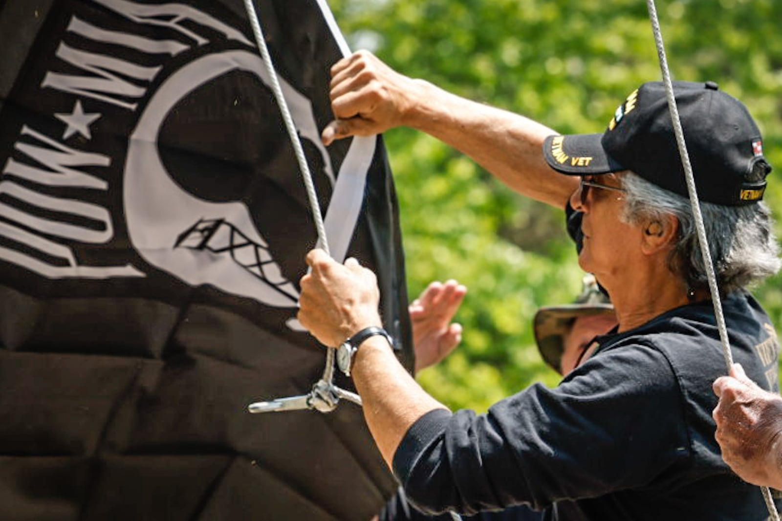 Vietnam veteran Mark Kucharski replaces the POW-MIA flag at the Vietnam Veterans Memorial Park in Dayton Friday May 19, 2023. JIM NOELKER/STAFF