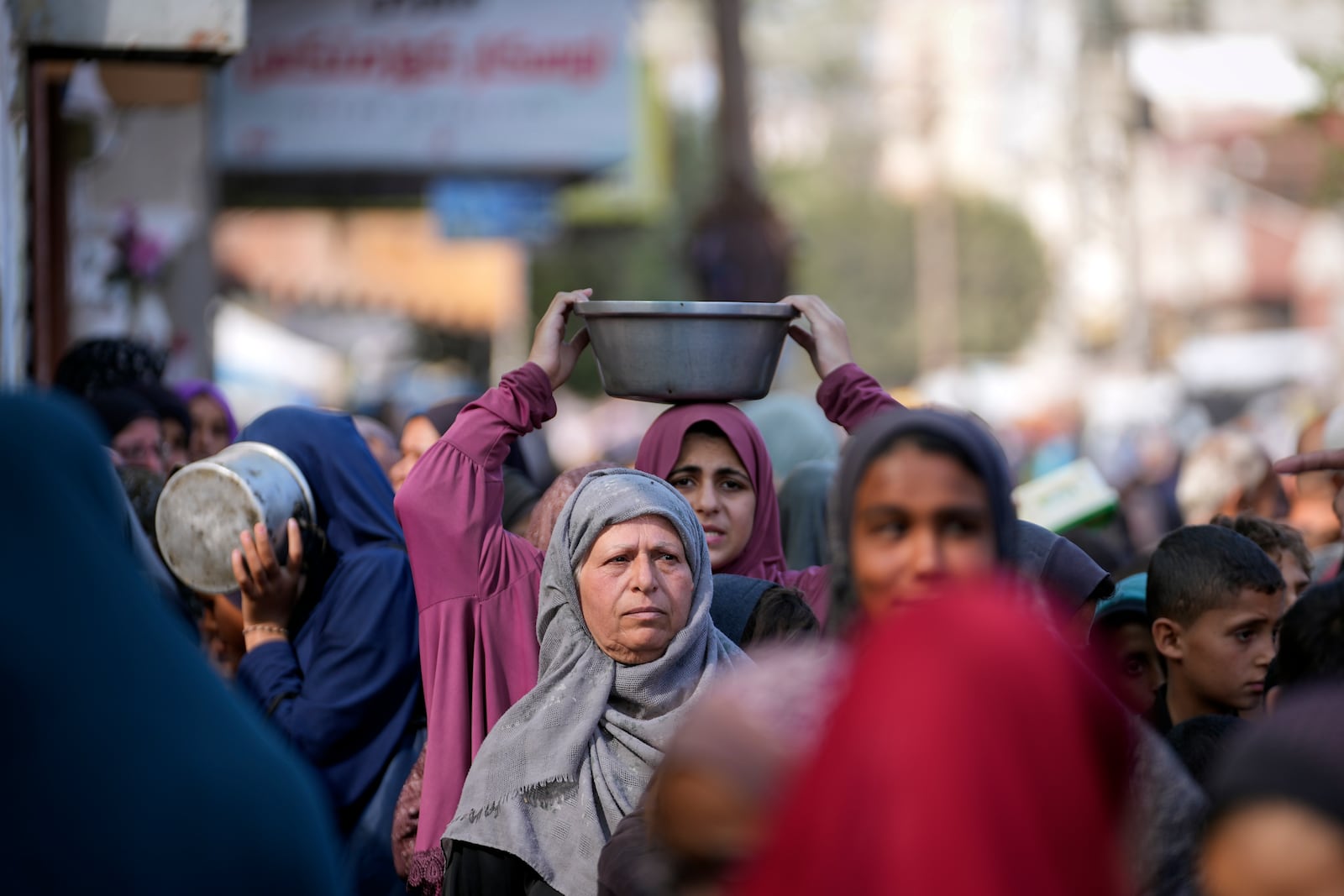 A Palestinian woman queues for food in Deir al-Balah, Gaza Strip, Monday, Nov. 18, 2024. (AP Photo/Abdel Kareem Hana)