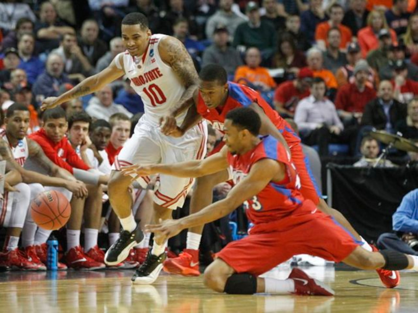 Ohio State’s LaQuinton Ross, left, goes after a loose ball with Dayton’s Kendall Pollard, center, and Vee Sanford in the second round of the NCAA tournament on Thursday, March 20, 2014, at the First Niagara Center in Buffalo, N.Y.