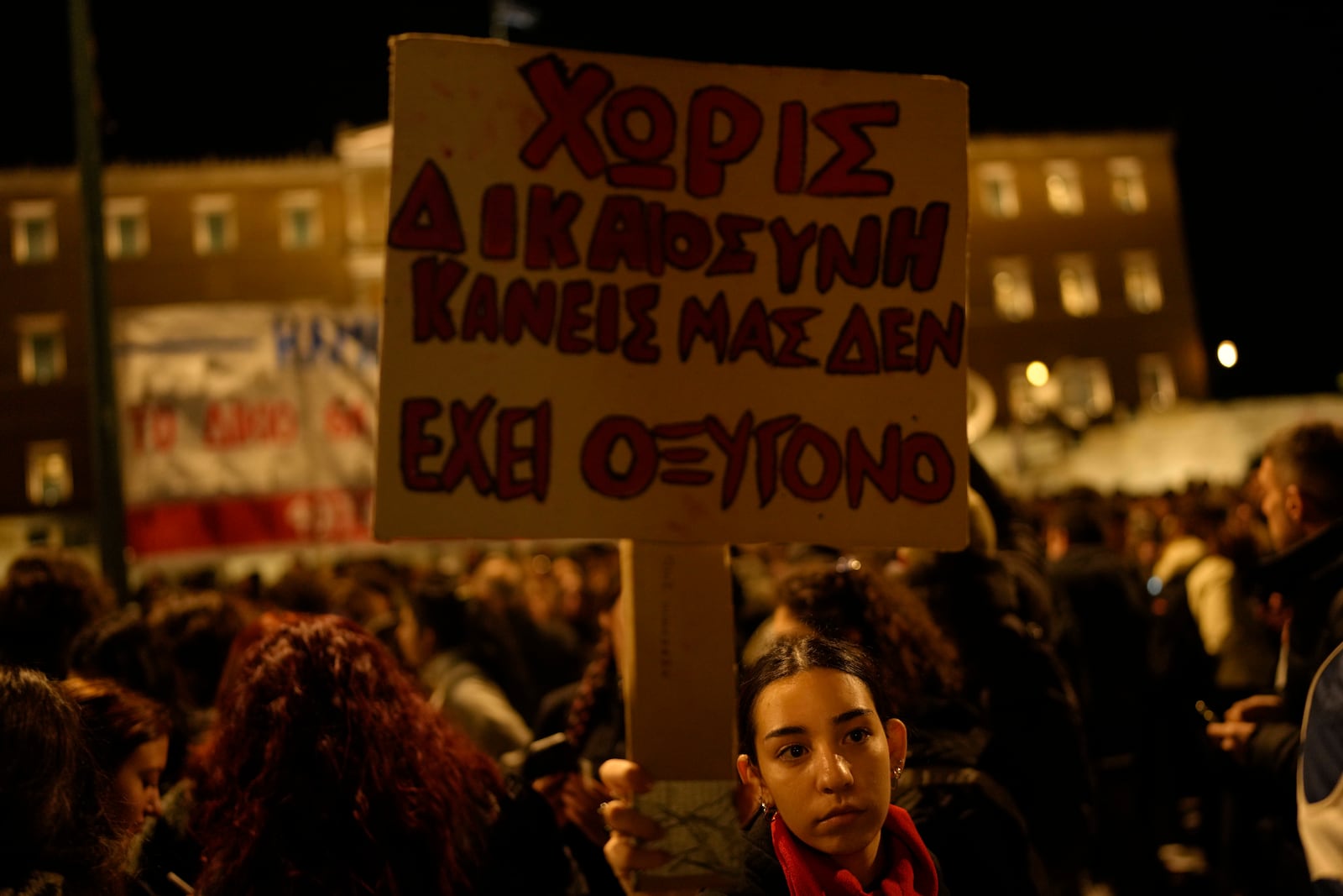 A protester takes part in a rally holding a placard that reads "Without justice none of us has oxygen," after the Greek opposition parties have challenged the country's center-right government with a censure motion in parliament over a devastating rail disaster nearly two years ago, in Athens, Wednesday, March 5, 2025. The phrase "I have no oxygen", was used by a victim of the deadly train accident, in a phone call to the emergency services. (AP Photo/Petros Giannakouris)