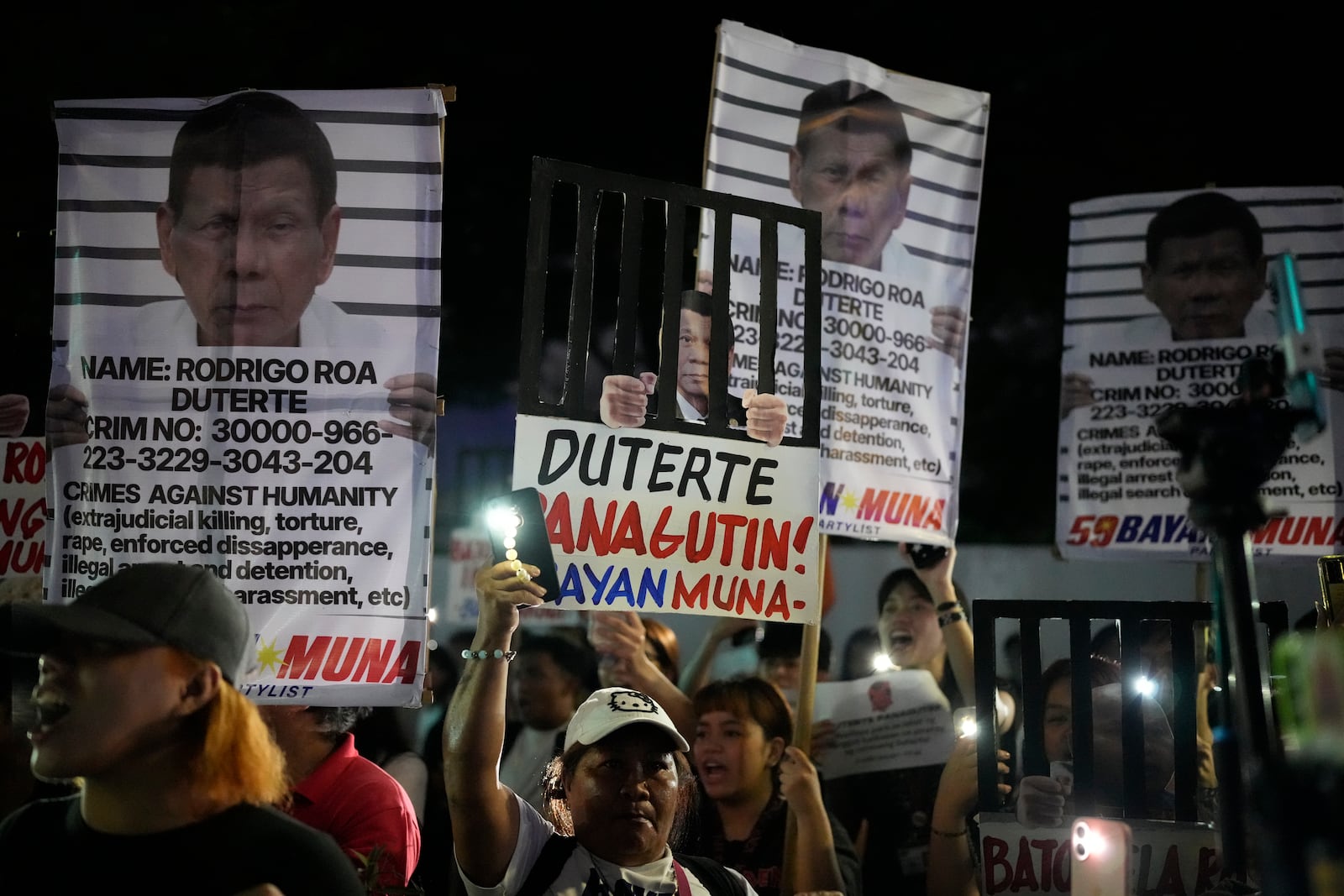 Protesters hold pictures of former President Rodrigo Duterte's as they call for justice to victims of the war on drugs during his administration in Quezon city, Philippines on Friday, March 14, 2025. (AP Photo/Aaron Favila)