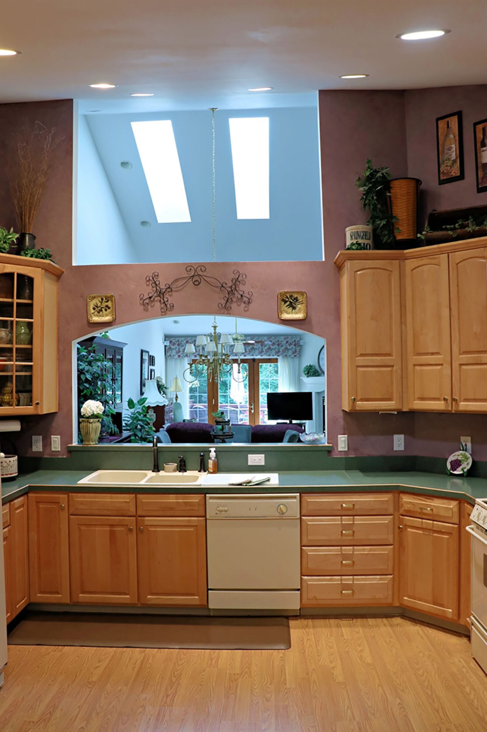 The vaulted ceiling of the kitchen extends through a cut out to allow the skylights above the great room to fill the kitchen with natural light. Light oak cabinetry wraps around three walls and appliances and includes a pantry cabinet, a corner display cabinet with glass-panel doors, and a planning desk tucked off the breakfast room. CONTRIBUTED PHOTO BY KATHY TYLER