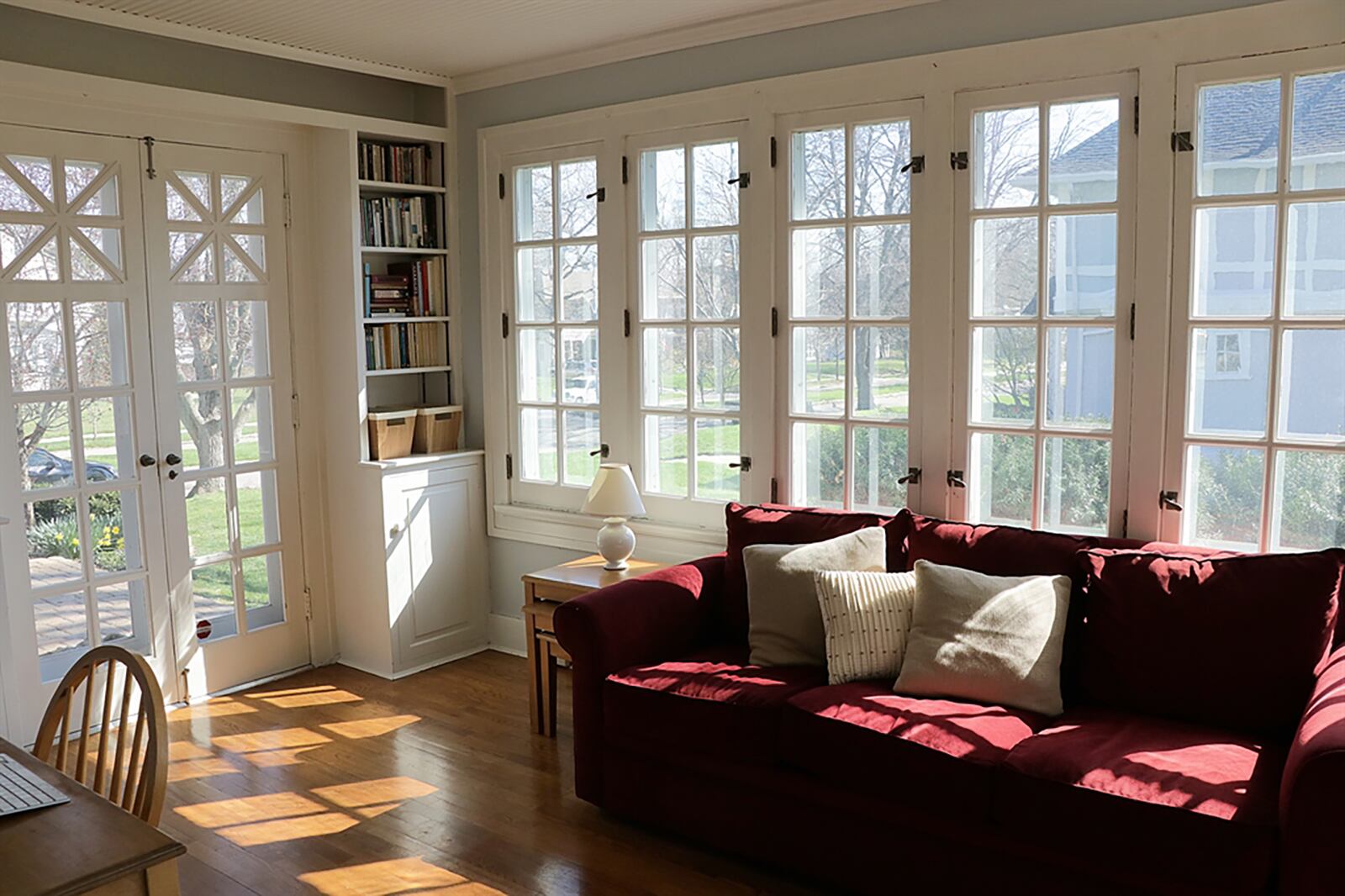 French doors in the sun room are flanked by built-in bookcases and open out to a side paver-brick patio. CONTRIBUTED PHOTO BY KATHY TYLER