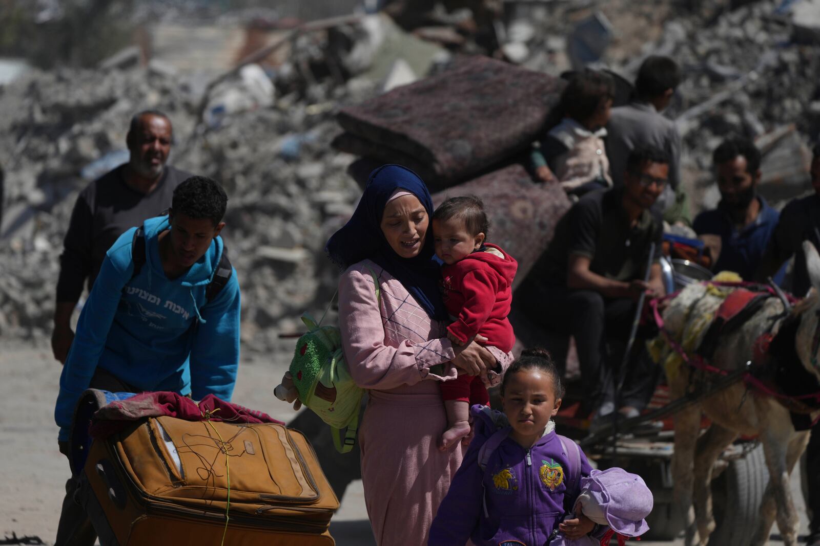 Displaced Palestinians, carrying their belongings traveling from Beit Hanoun to Jabaliya, a day after Israel's renewed offensive in the Gaza Strip, Wednesday, March 19, 2025. (AP Photo/Jehad Alshrafi)