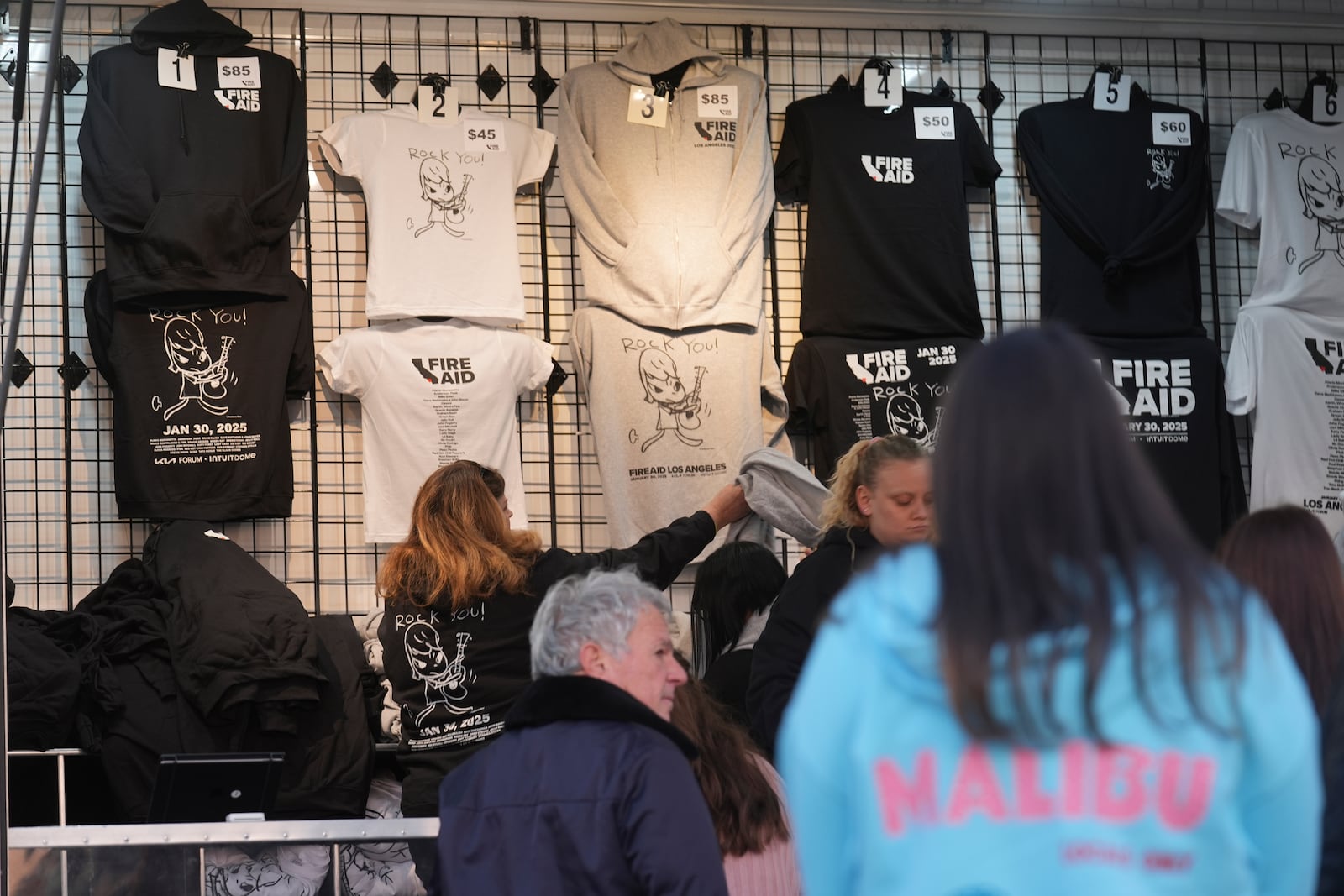 T-shirts promoting the FireAid benefit concert are seen on display on Thursday, Jan. 30, 2025, at The Forum in Inglewood, Calif. (AP Photo/Chris Pizzello)