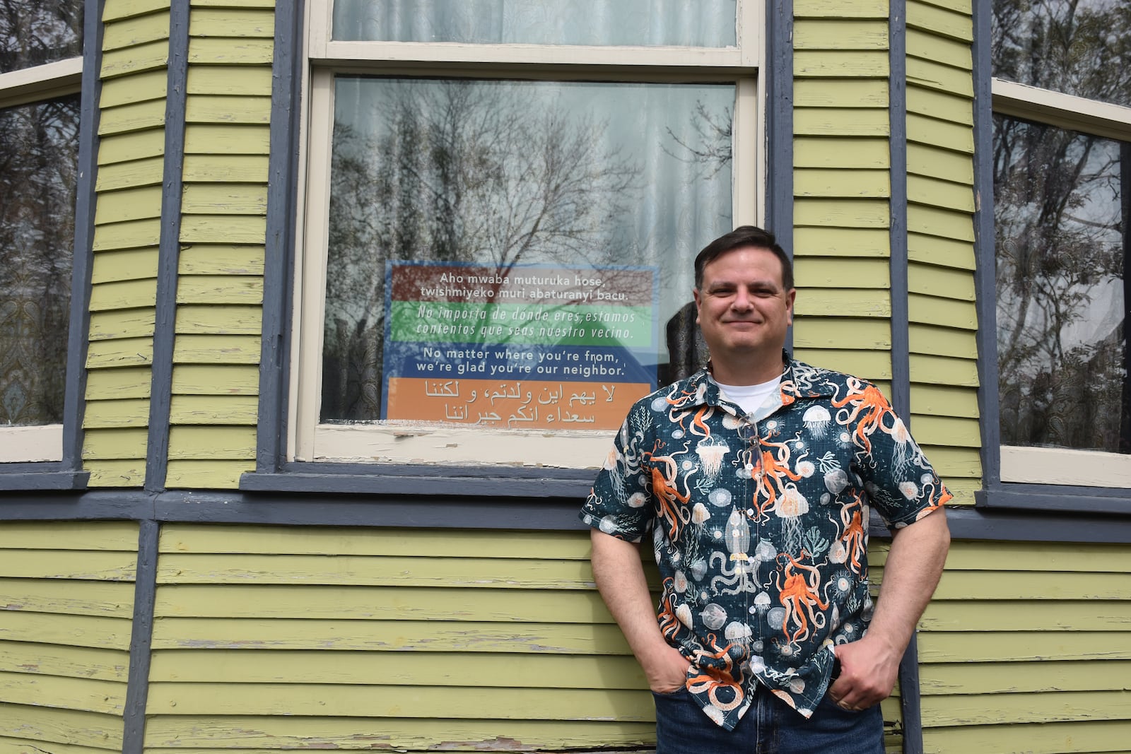 Bill Kennedy, who lives in Dayton’s South Park neighborhood, has a sign in the front window of his home that says in multiple languages, “No matter where you’re from, we’re glad you’re our neighbor.” Kennedy said he'd love to have immigrants live next door. CORNELIUS FROLIK / STAFF