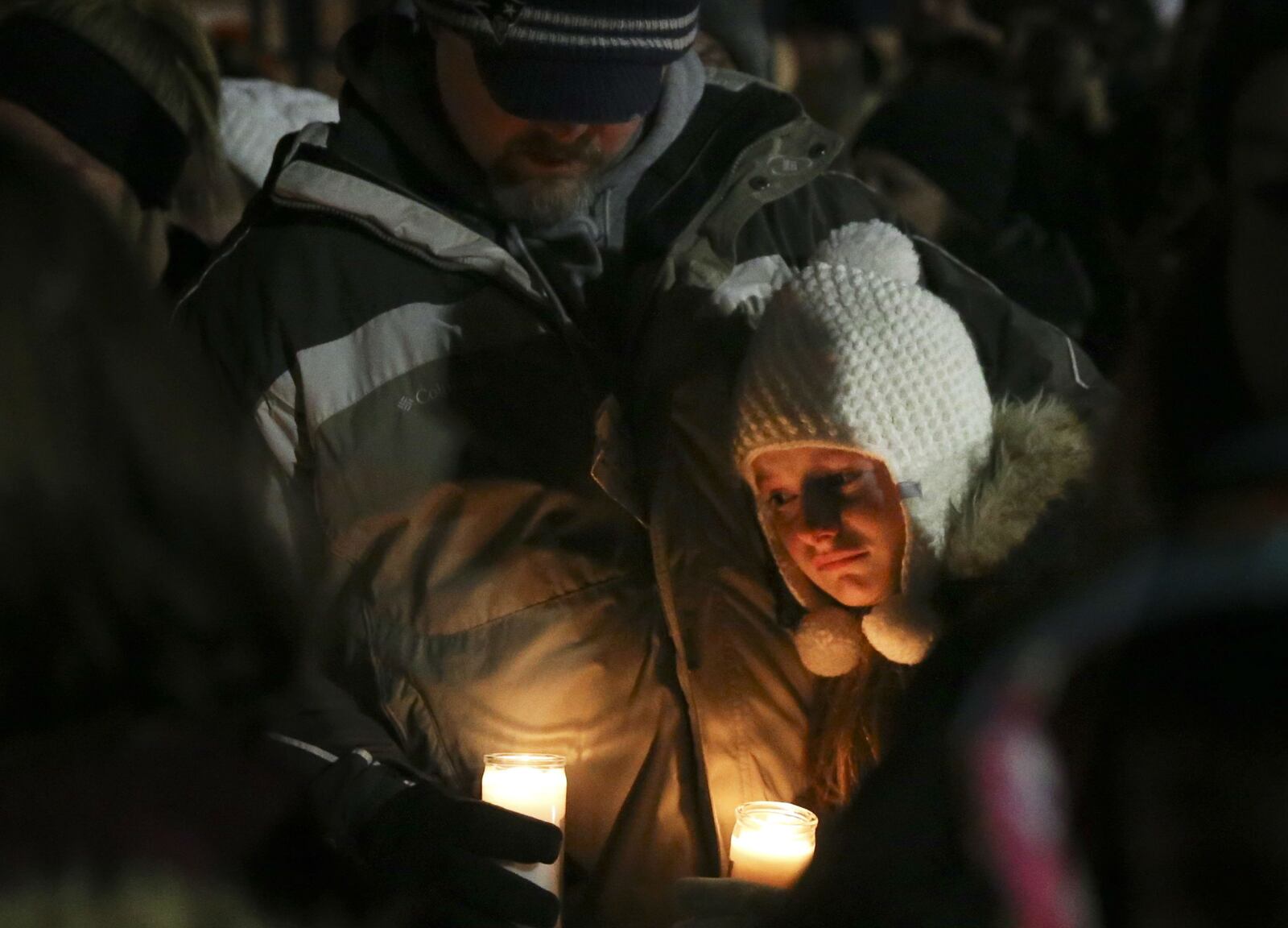 Jason Shaw comforts his daughter Ryley, 10, as they attend a candlelight vigil Sunday, Dec. 30, 2018, for Kate Kasten, her children, Zoe Kasten, 8, and Jonathan Kasten, 10, and Kate Kasten's mother, Jane Moeckel, 61, at the children's school, Harris Elementary School in St. Charles, Mo. Police and prosecutors allege that Kate Kasten's boyfriend, Richard Darren Emery, 46, gunned down the family Friday, Dec. 28, 2018, in the home he shared with the Kastens. Emery is also accused of shooting at police officers and stabbing a woman he tried to carjack as he fled the area.