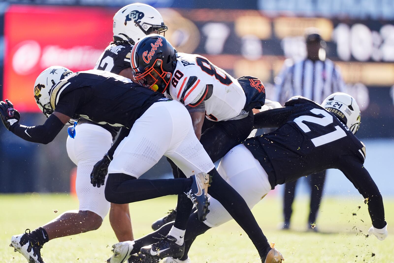 Oklahoma State wide receiver Brennan Presley, center, is tackled after pulling in a pass by Colorado cornerback Colton Hood, left, and safety Shilo Sanders in the first half of an NCAA college football game Friday, Nov. 29, 2024, in Boulder, Colo. (AP Photo/David Zalubowski)