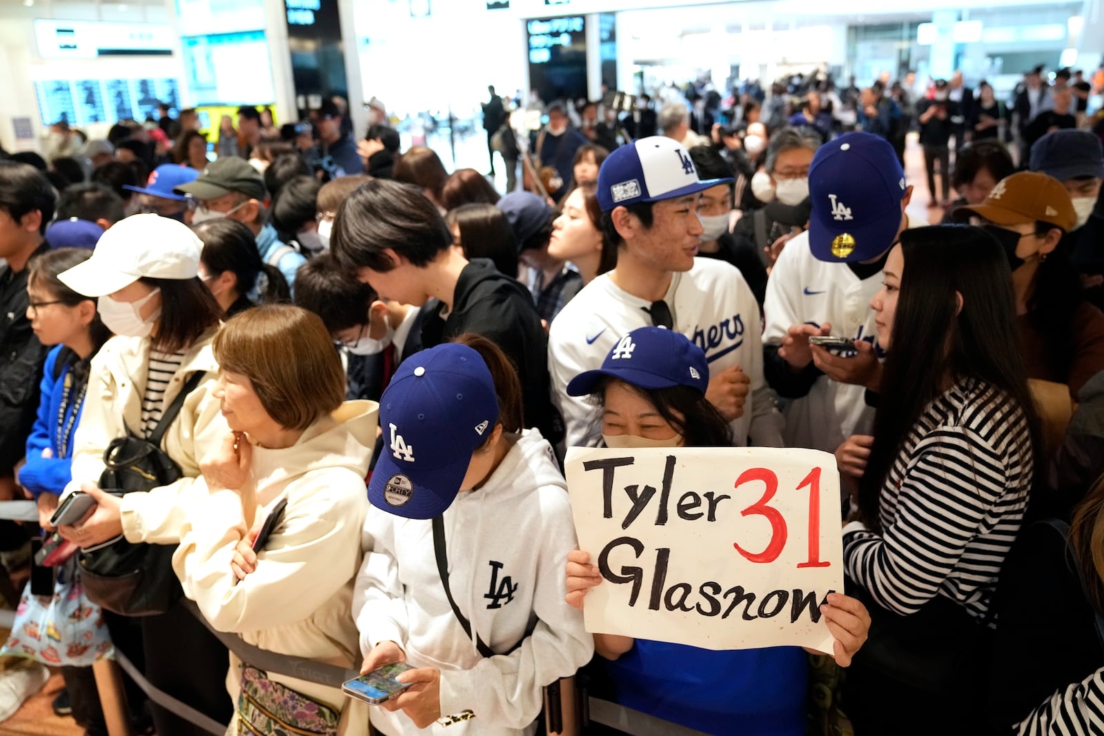 Fans of Los Angeles Dodgers wait for the team arrival at Tokyo International Airport Thursday, March 13, 2025, in Tokyo, as Los Angeles Dodgers is scheduled to play their MLB opening games against Chicago Cubs in Tokyo on March 18-19. (AP Photo/Hiro Komae)