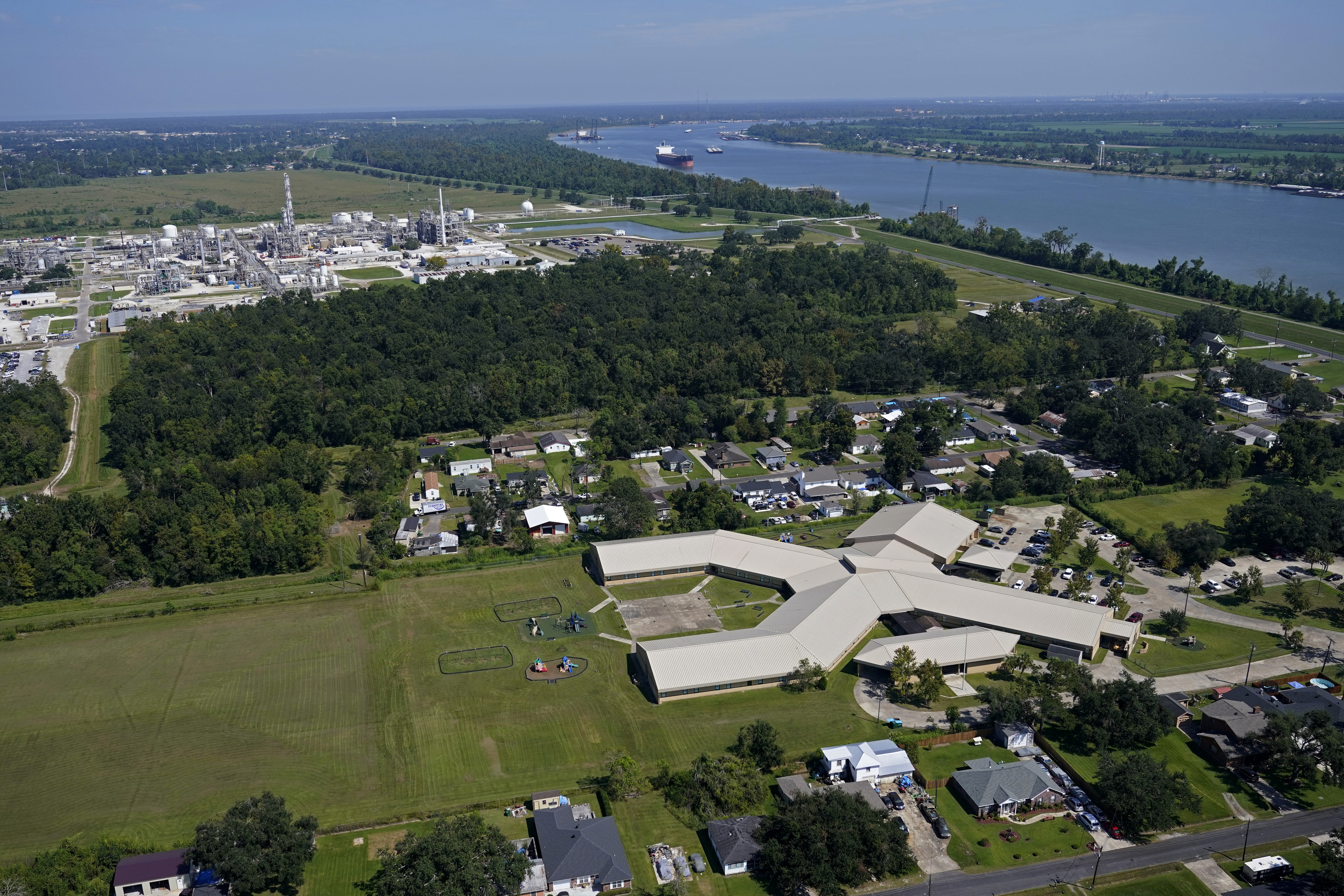 FILE - The Fifth Ward Elementary School and residential neighborhoods sit near the Denka Performance Elastomer Plant, back left, in Reserve, La., Sept. 23, 2022. (AP Photo/Gerald Herbert, File)